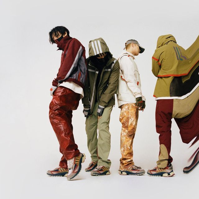 Four people in stylish, colorful outdoor clothing and sneakers, standing in a line against a plain background, with some distortion or digital glitch.