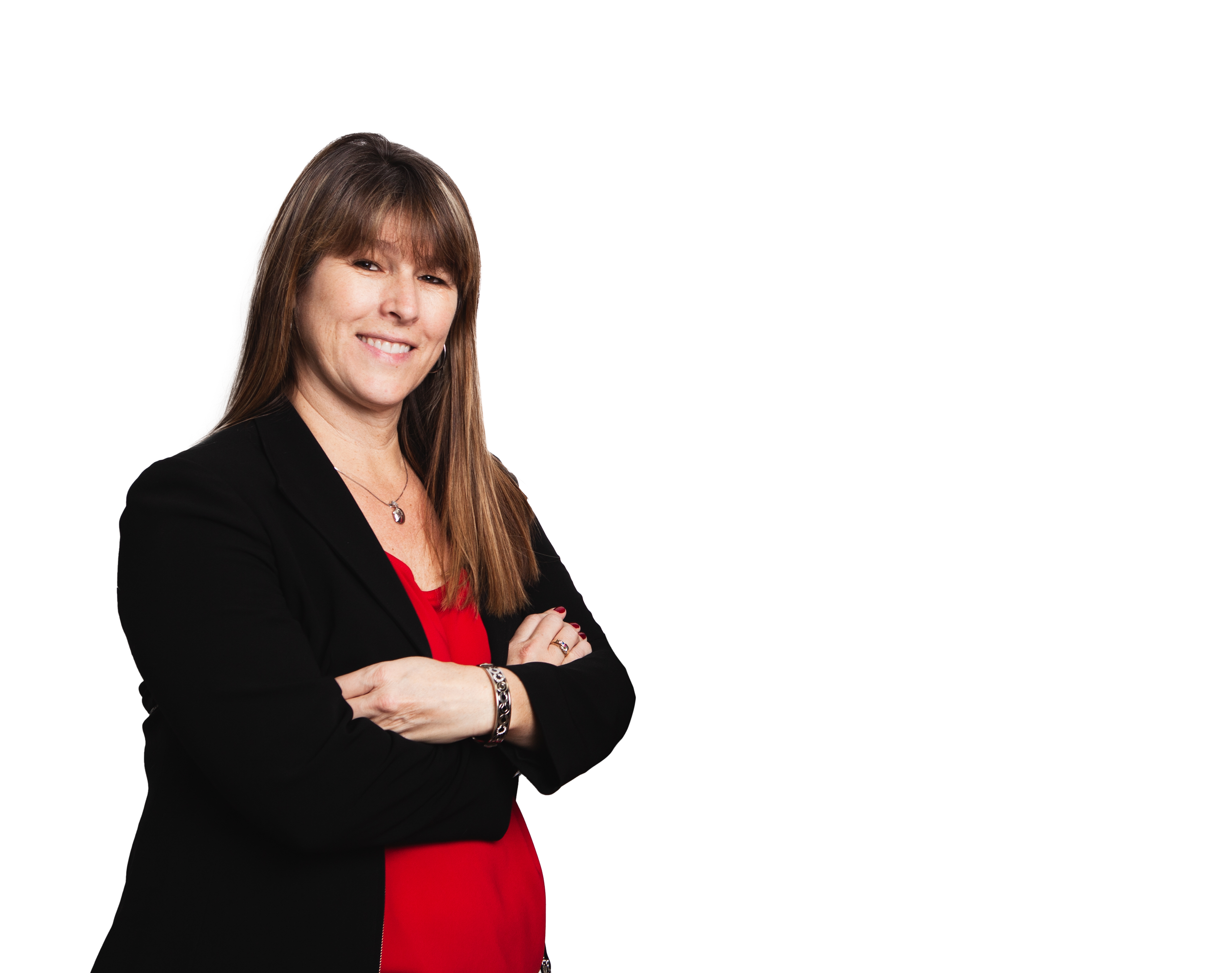 A woman with long brown hair wearing a black blazer over a red top, smiling with arms crossed, standing against a white background.