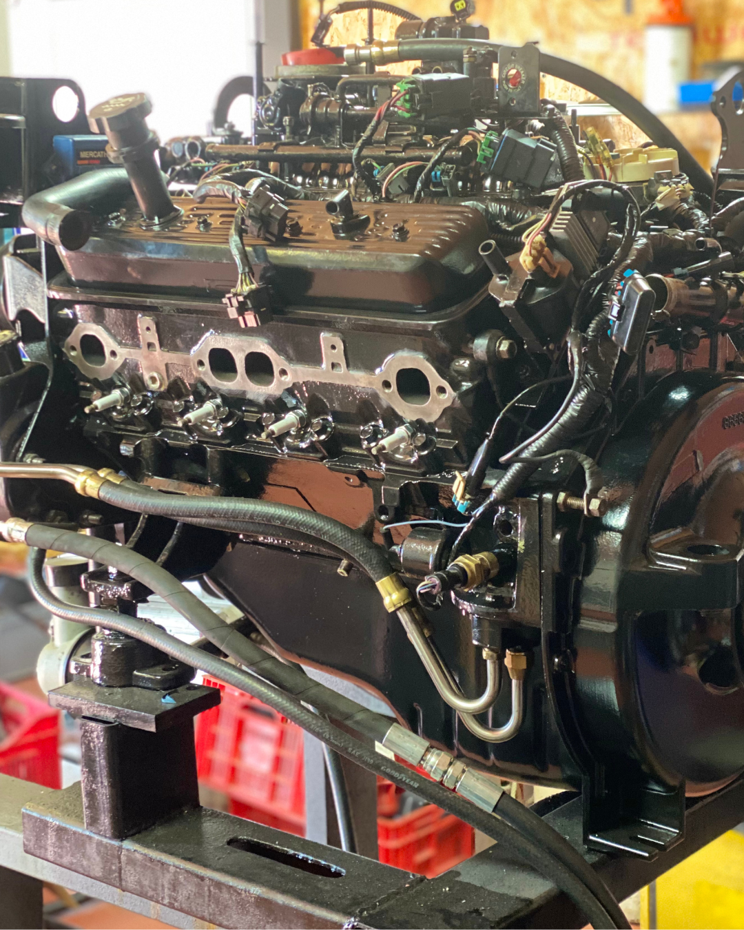 A mechanical engine assembly on a workbench with various wires, hoses, and engine parts visible. montar motor barco , nauti campello, alicante