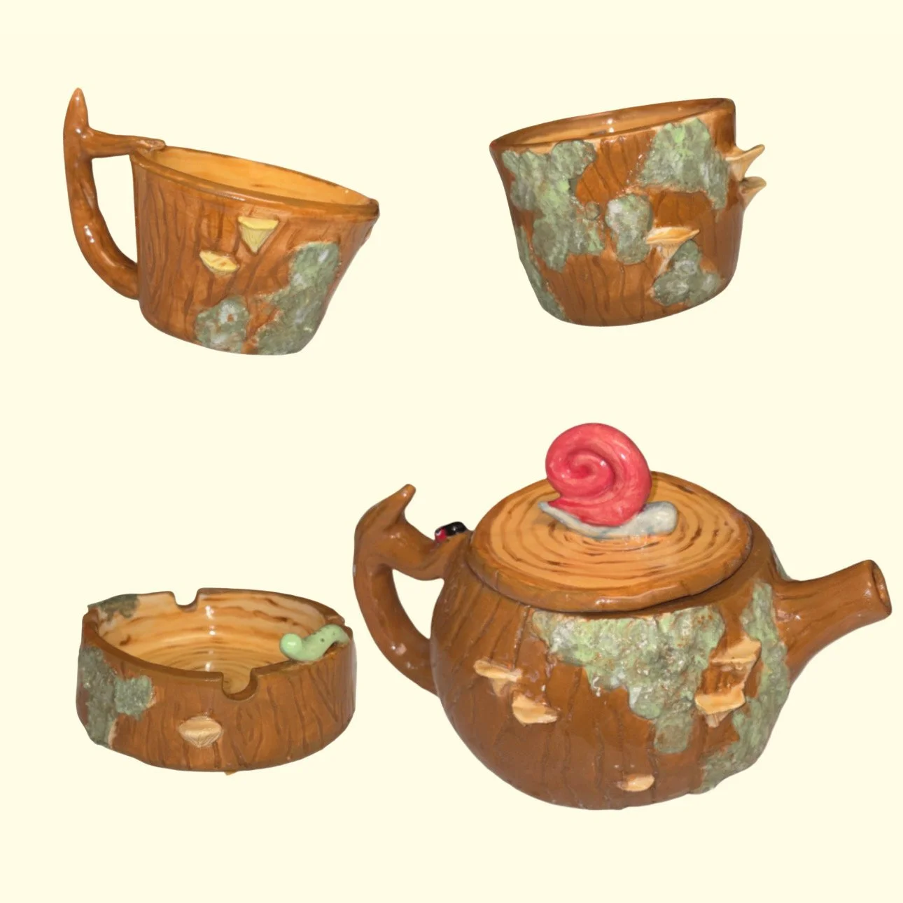 Ceramic tea set with a teapot, two cups, and a tray, designed to look like a wood log with moss accents.