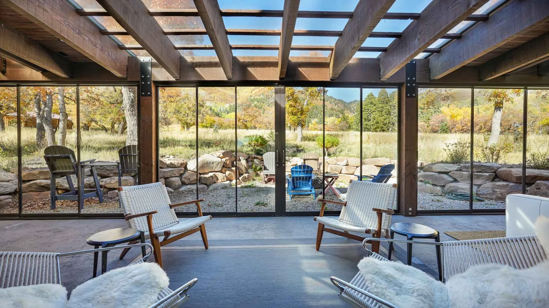 Interior of a room with large glass sliding doors leading to an outdoor area with trees and rocks built by home contractors durango
