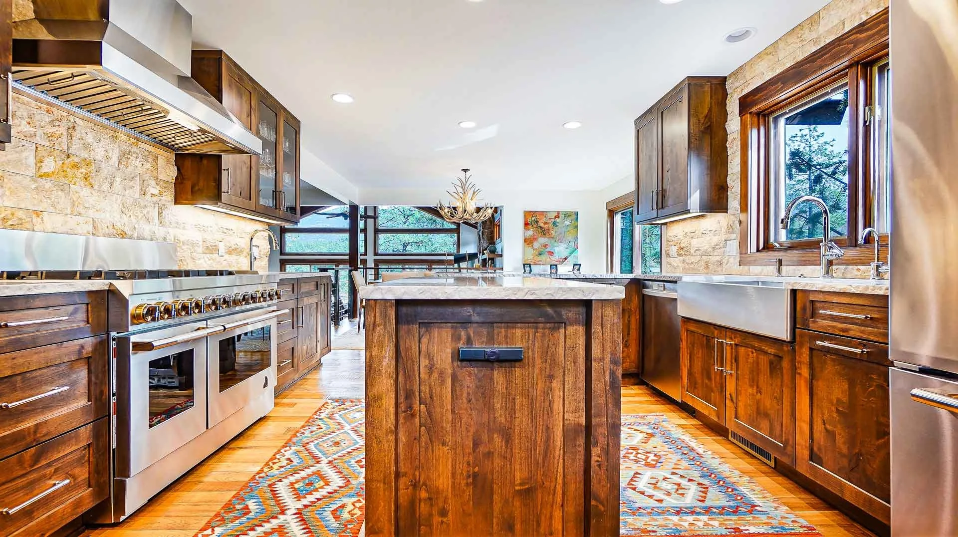 Durango Modern kitchen with dark wood cabinets, stainless steel appliances, stone backsplash, and large windows with wooden frames built by Taylor Builders kitchen contractors Durango