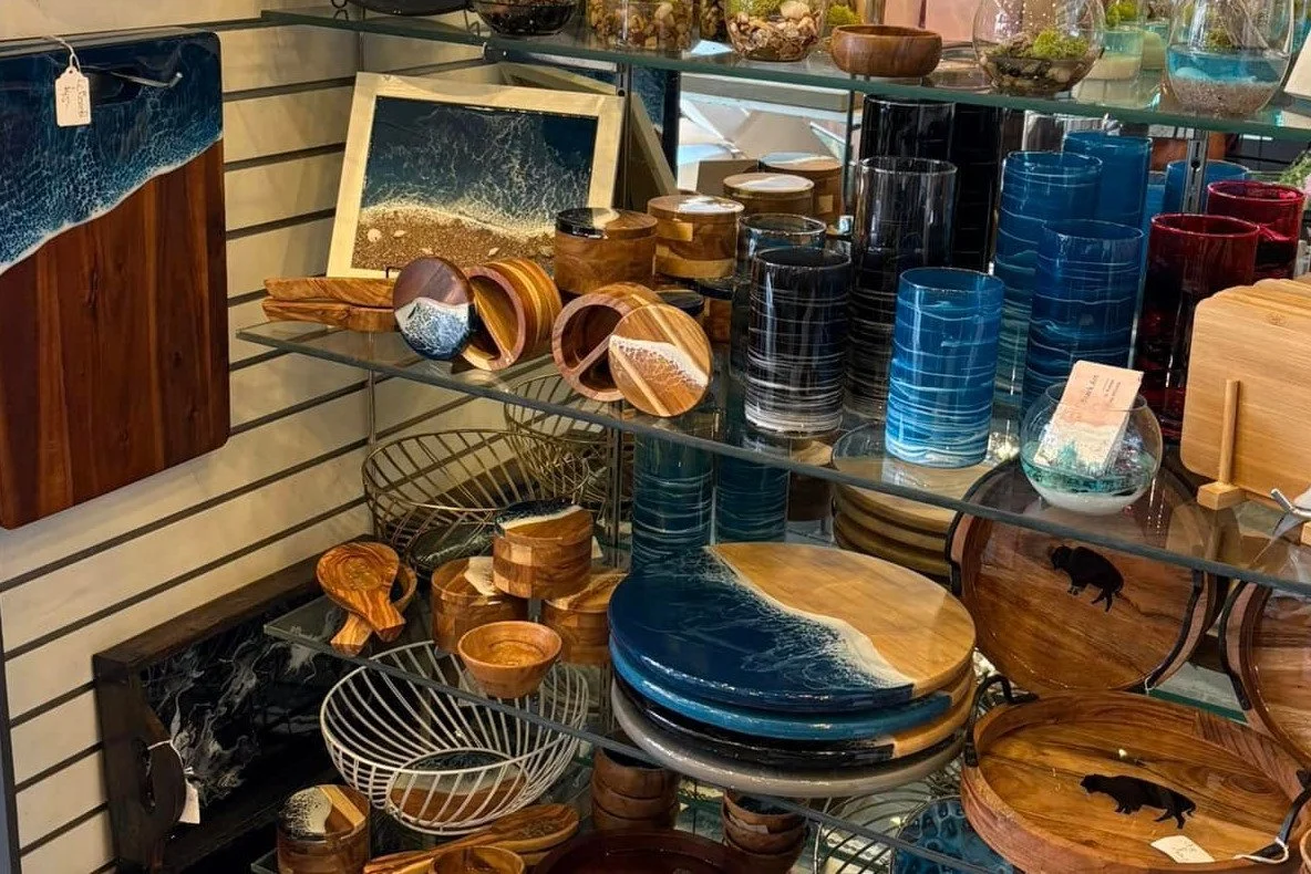 Display of handmade serving boards, resin clocks, trays, and sports-themed art by Stark Art.