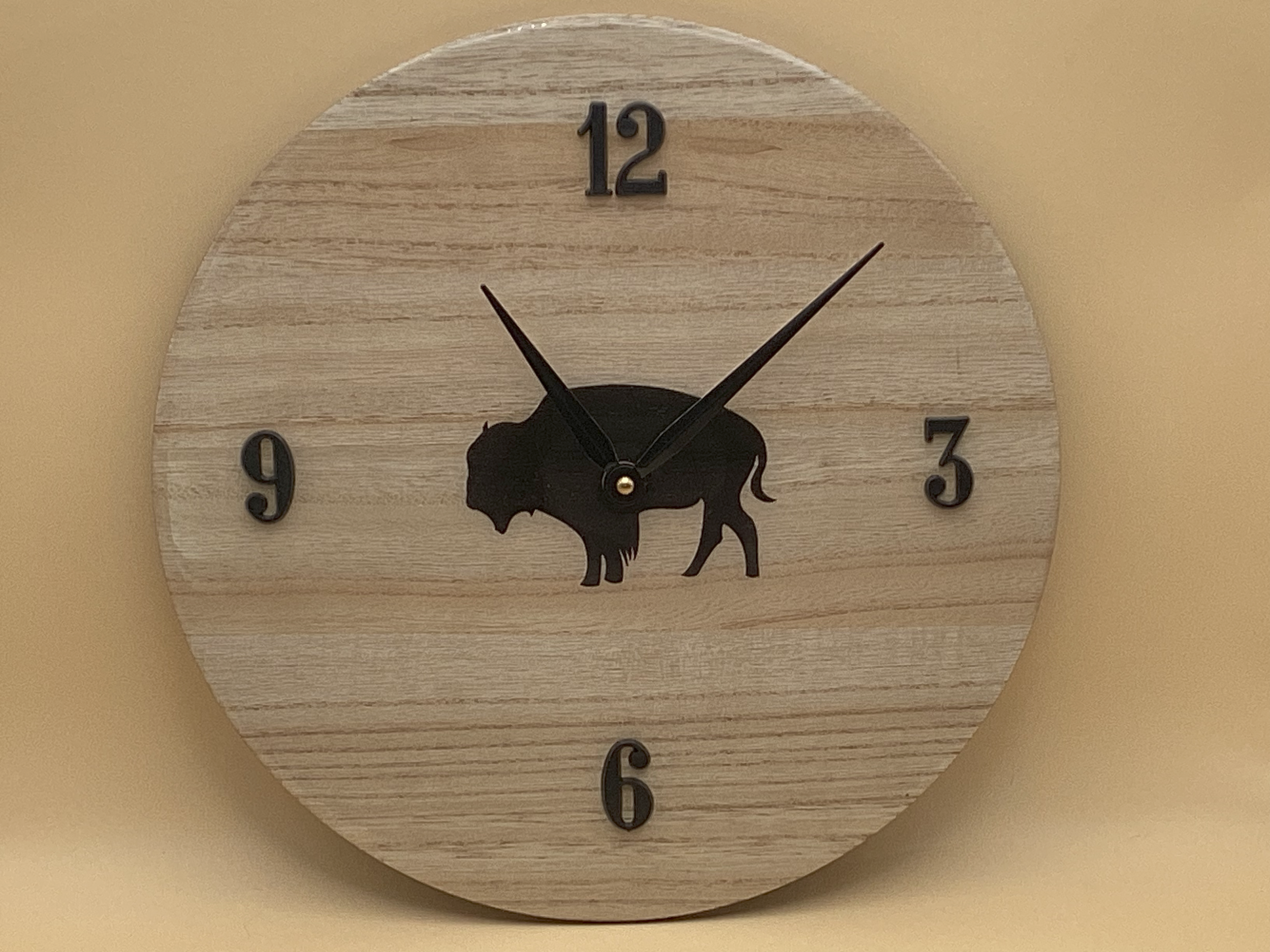 Round wood-grain wall clock with black numerals and a central black bison silhouette inspired by Buffalo Bills themes.