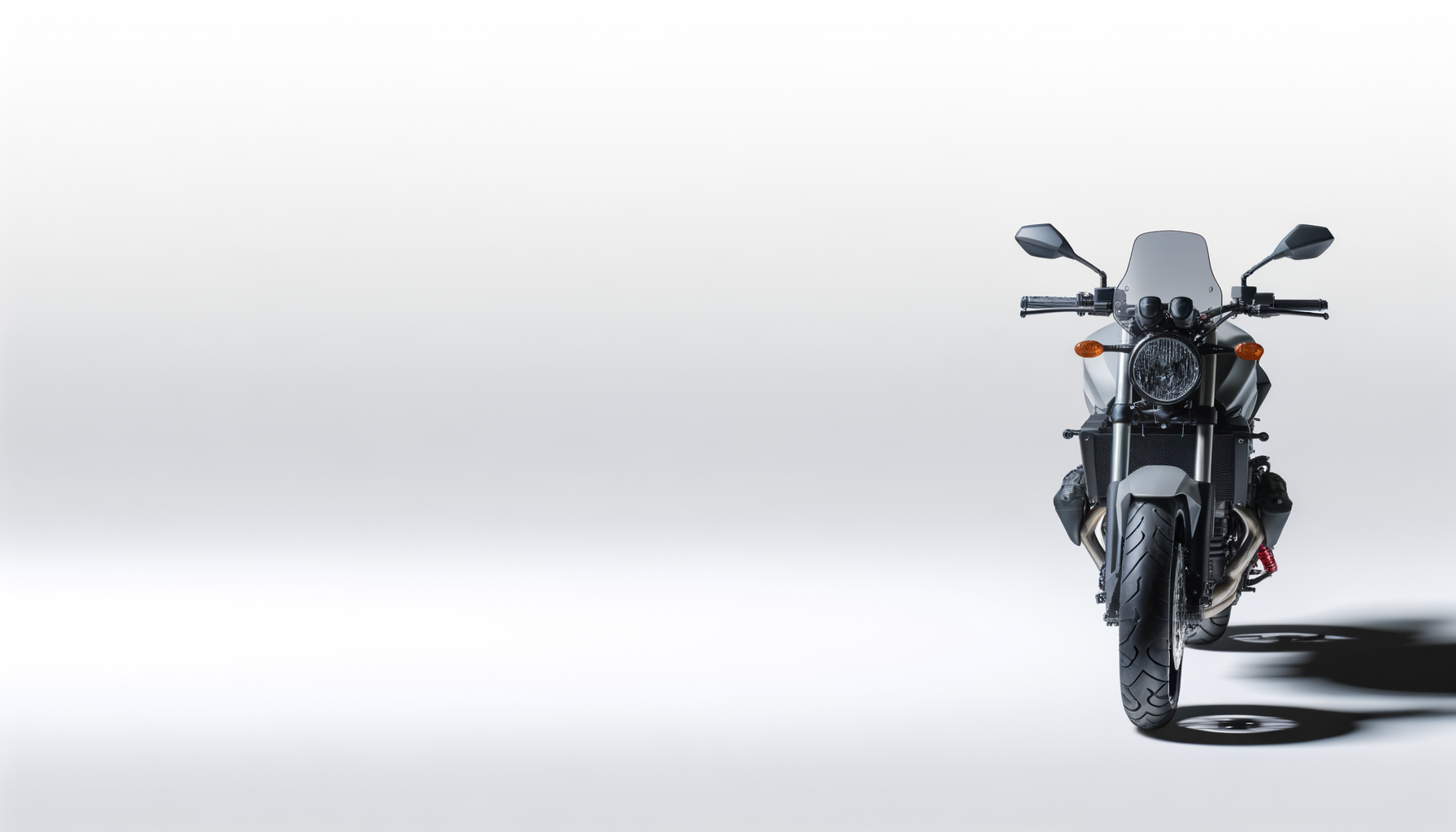 Front view of a modern motorcycle with a windshield and black tires, casting a shadow on a plain white background.
