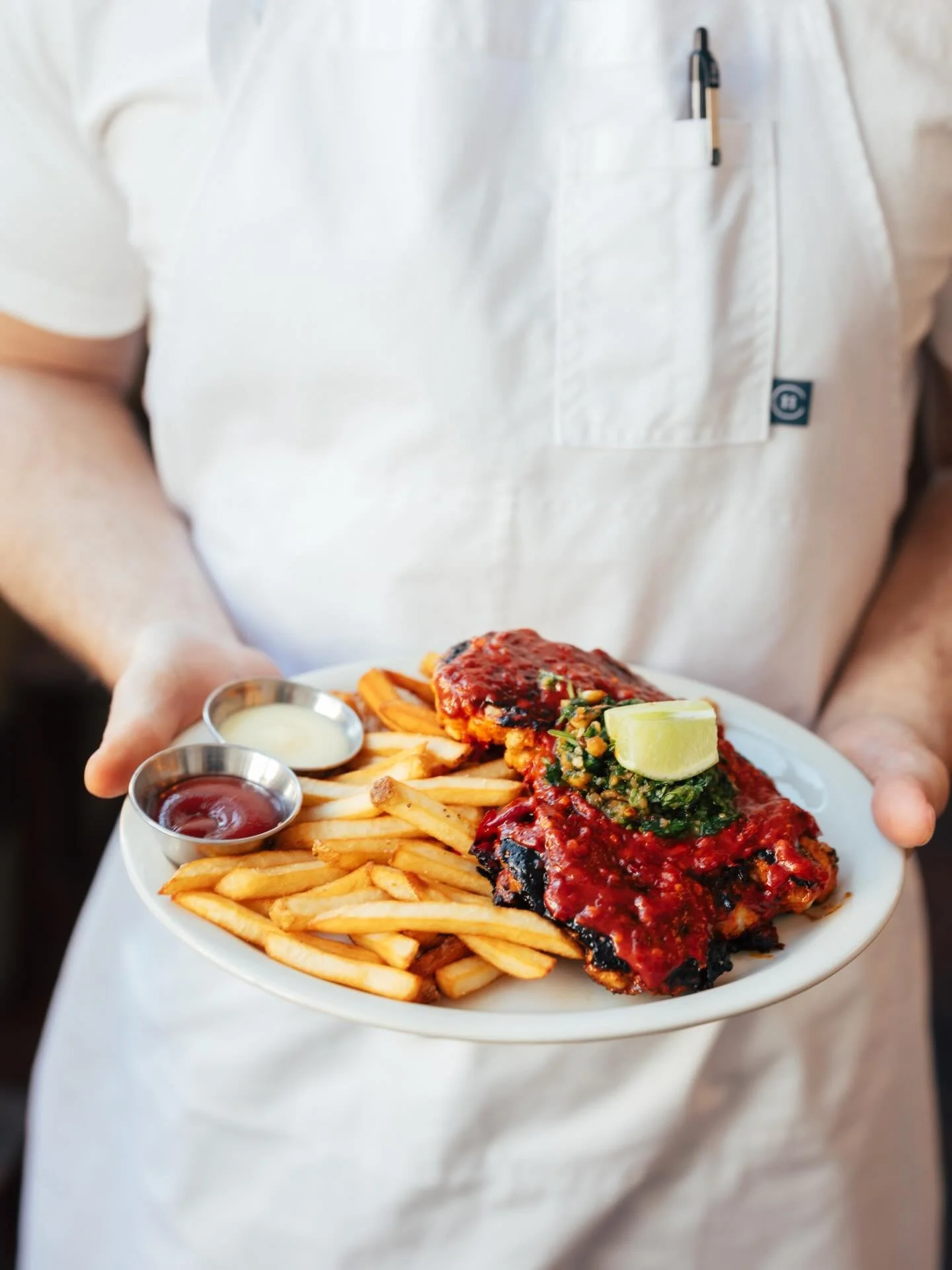 In 2019, we set out to create a chicken dish with bold, layered flavor that still felt right at home on a Southern table. The result? Our not-so-traditional piri piri - a Southern spin on the Portuguese classic.

Half grilled chicken under a brick, p