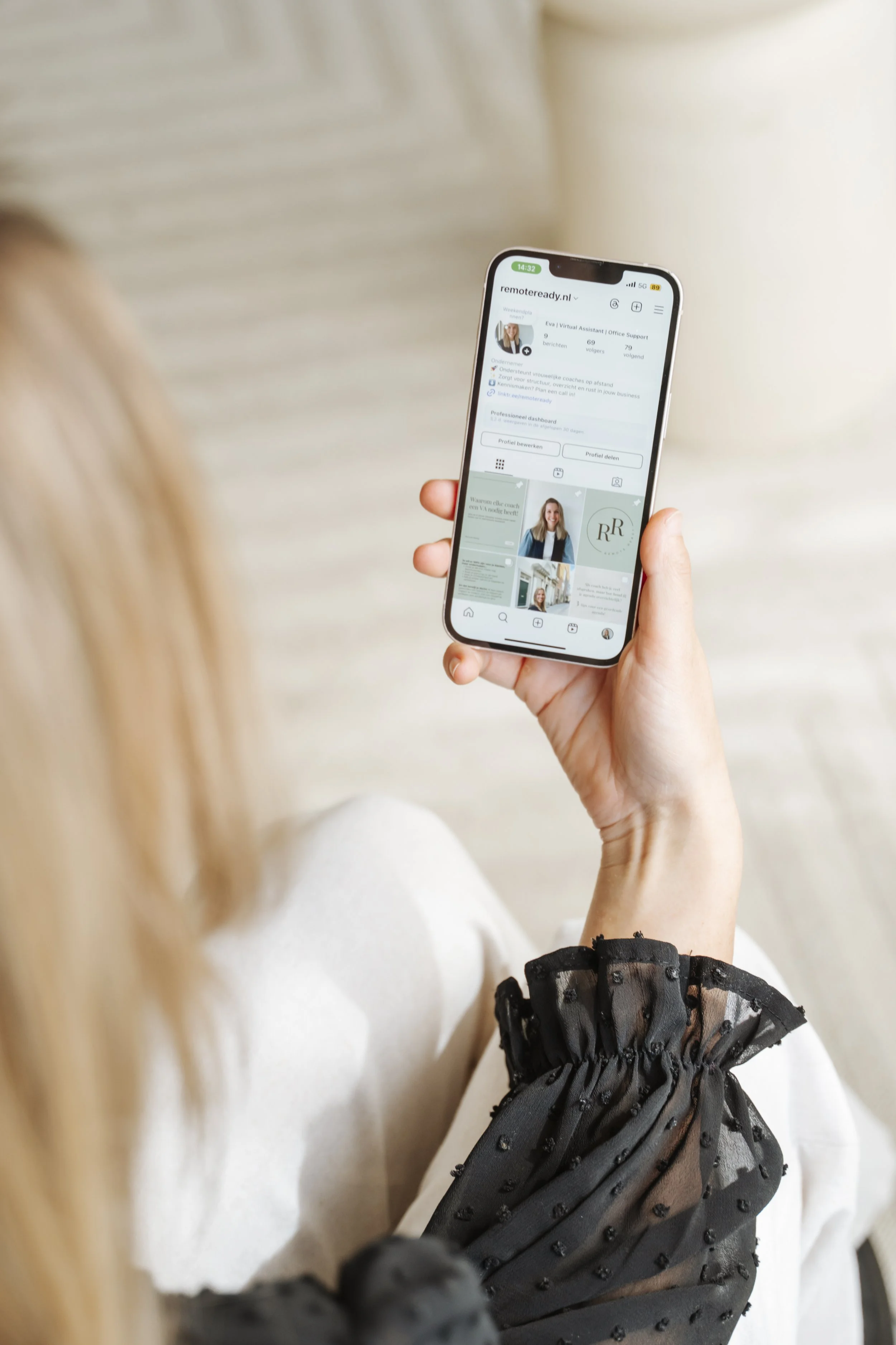 Een persoon houdt een smartphone vast die een Instagram-profiel weergeeft.