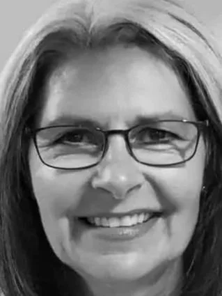 Close-up of a smiling woman with glasses and medium-length hair