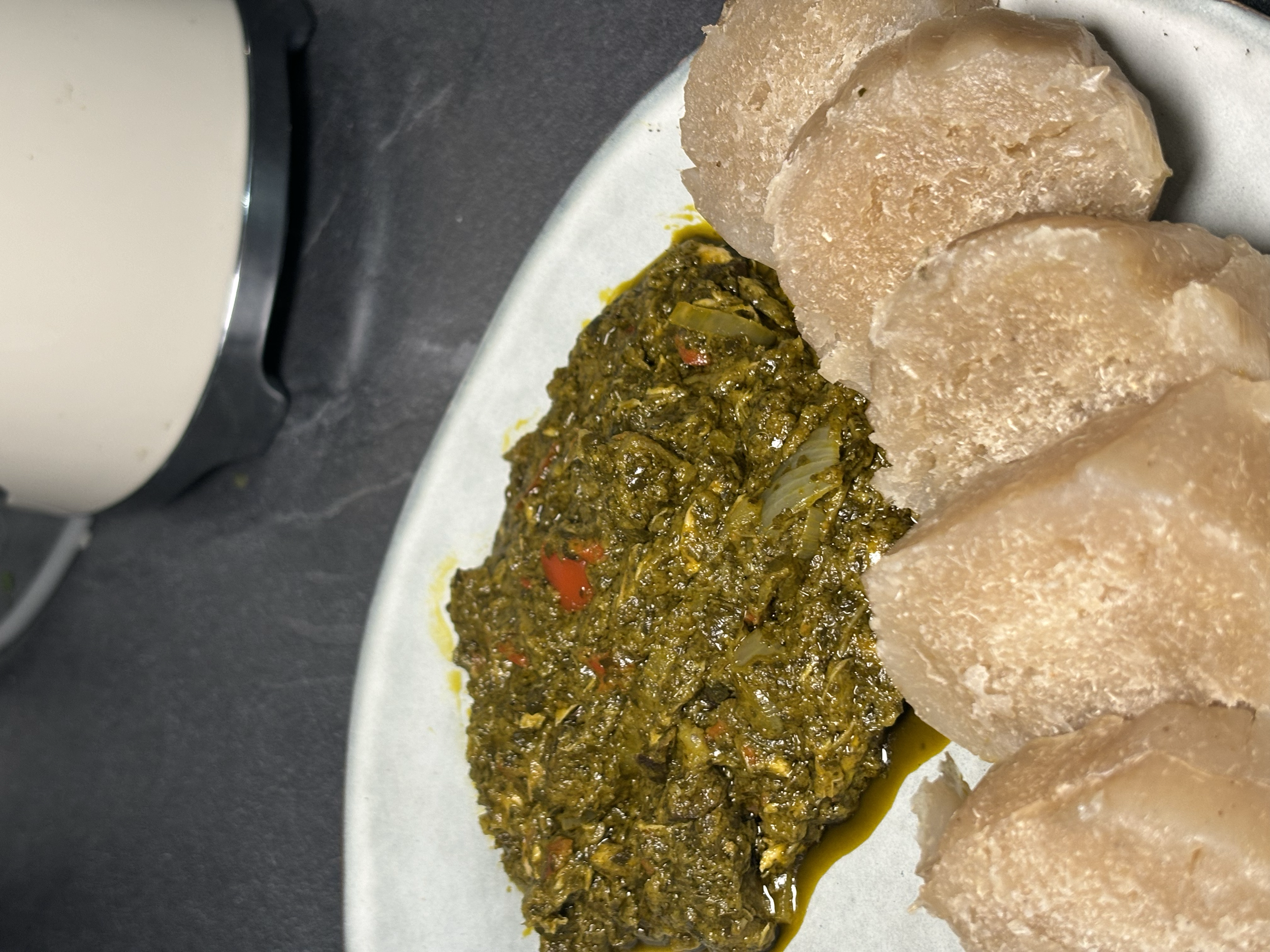 Une assiette contenant un morceau de viande en sauce épicée et plusieurs morceaux de gomme ivoire