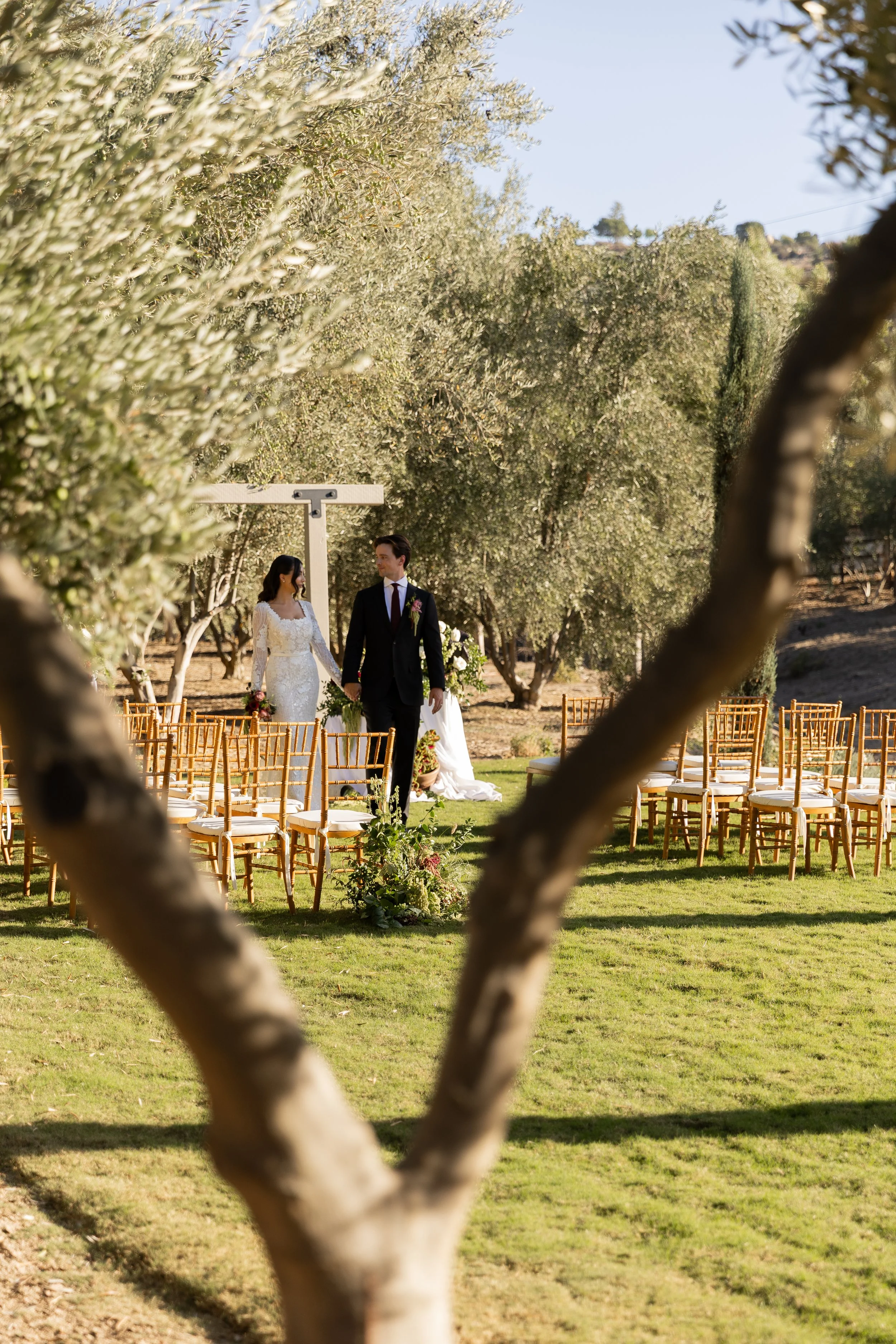 Bride and groom walk down the wedding aisle in distance in Hemete, CA