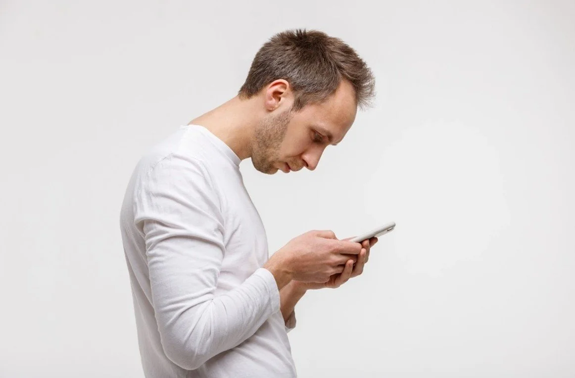 Man looking at his phone with bad posture how does bad posture affects brain health. Image used by Dr. Jessica Knape of HealthSpan Internal Medicine in Boulder, CO.jpg