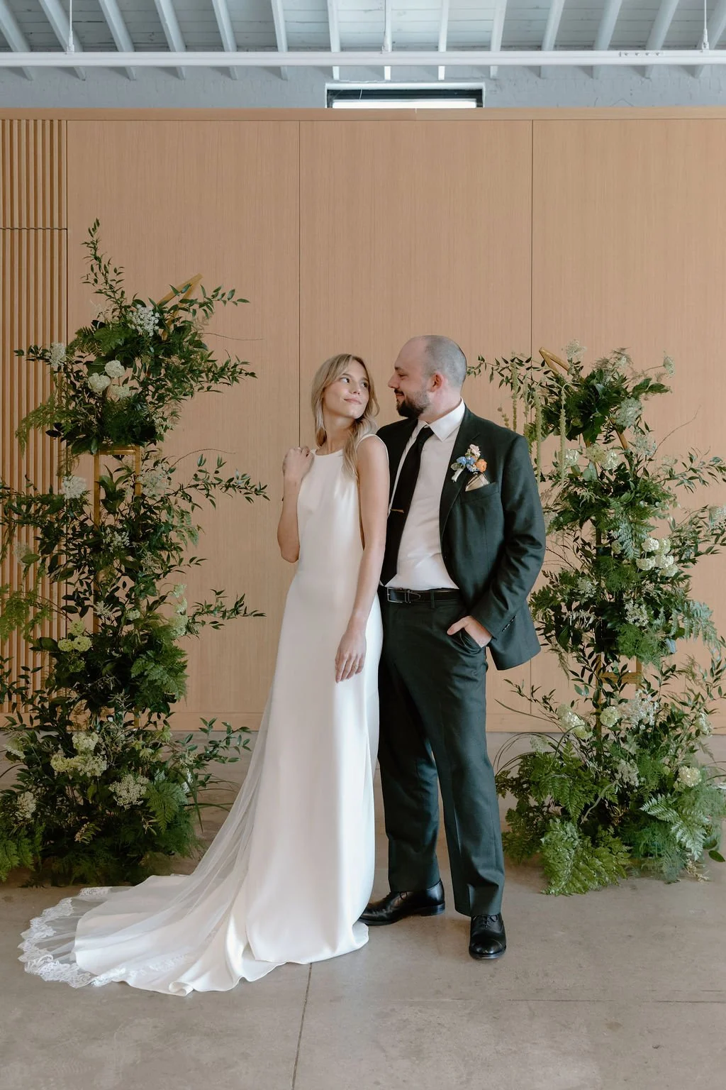 Bride and groom with ceremony greenery