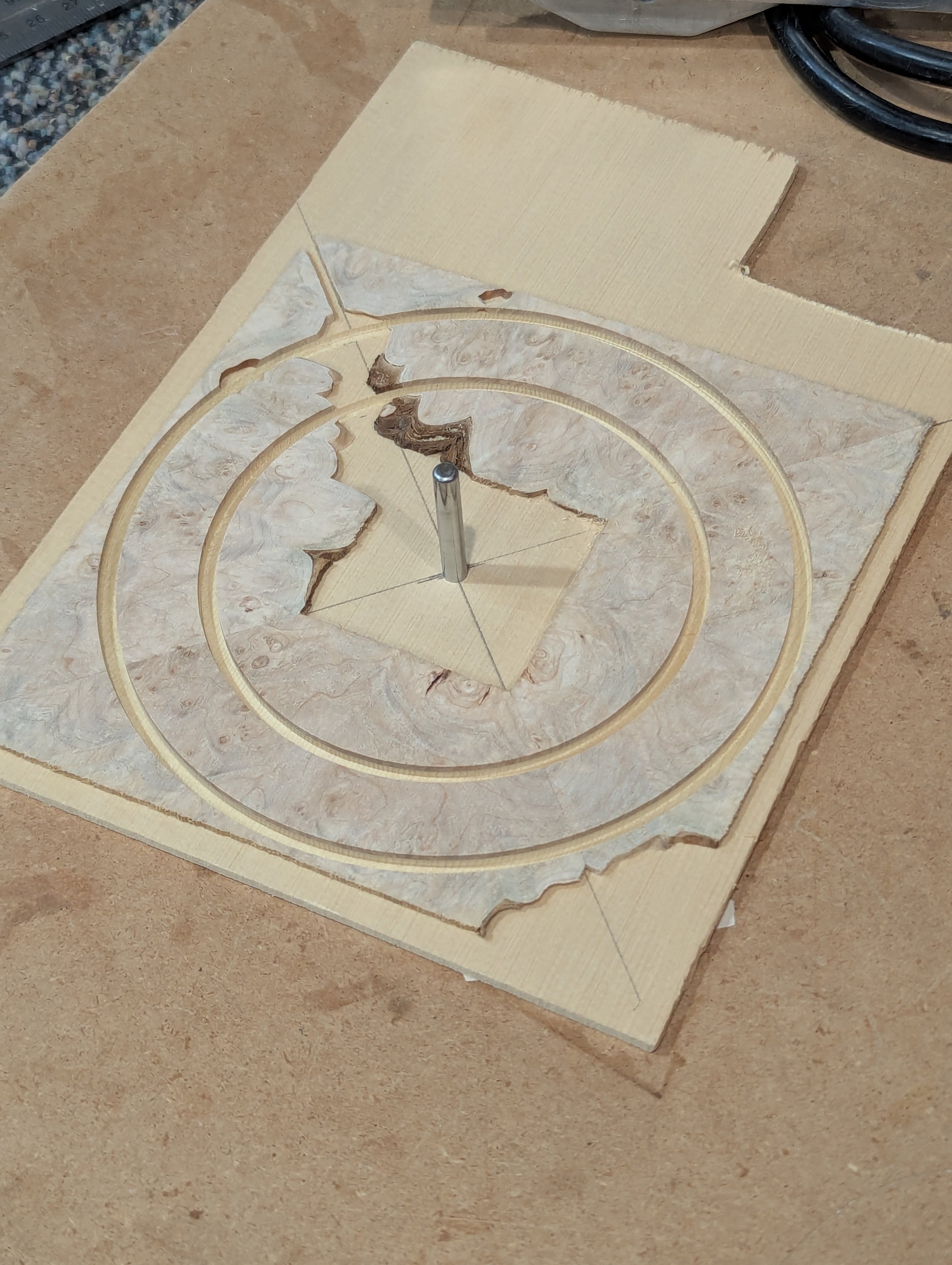 A piece of burl wood with guitar rosette lines cut out of.