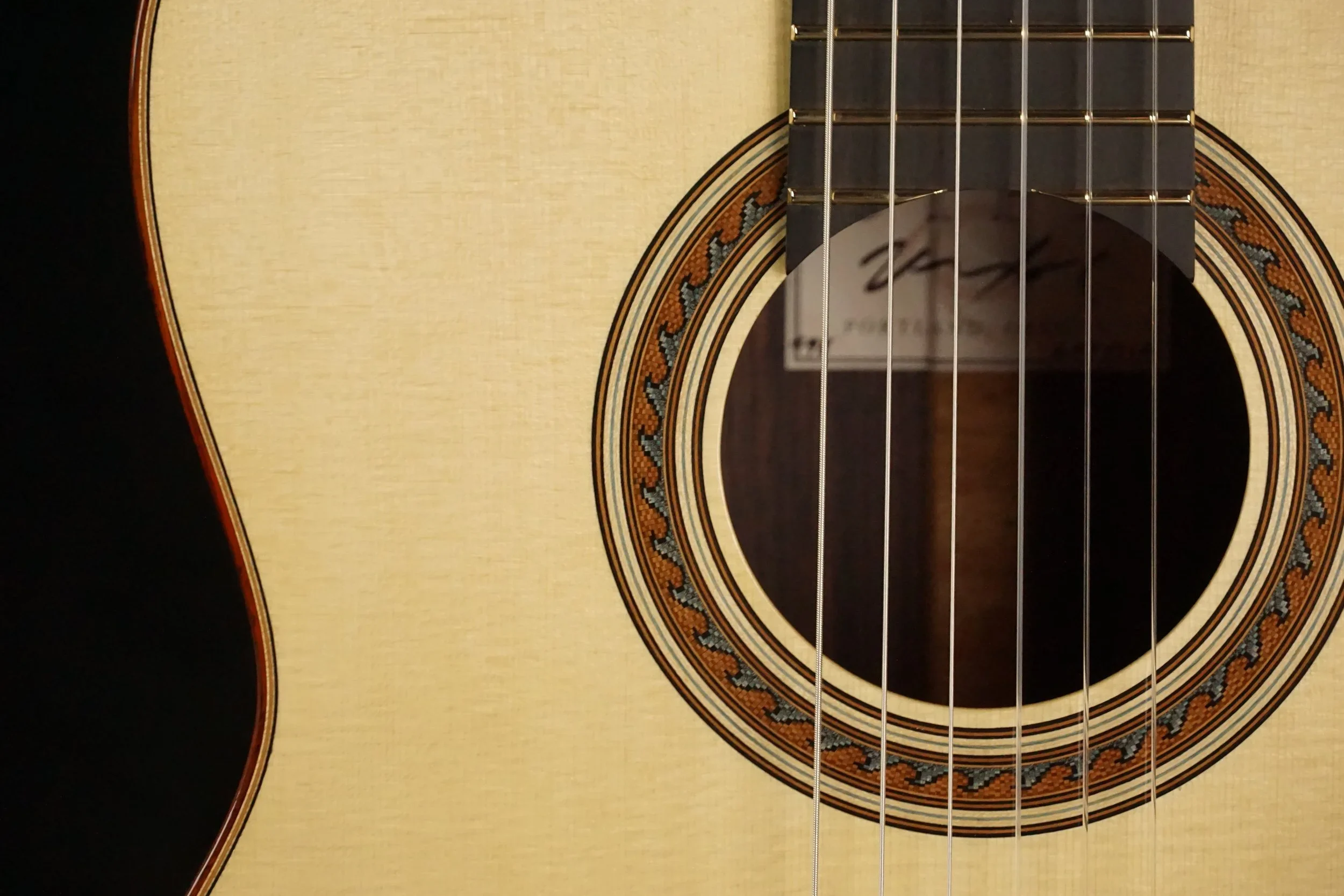 Close up of a wave rosette on a spruce guitar top.
