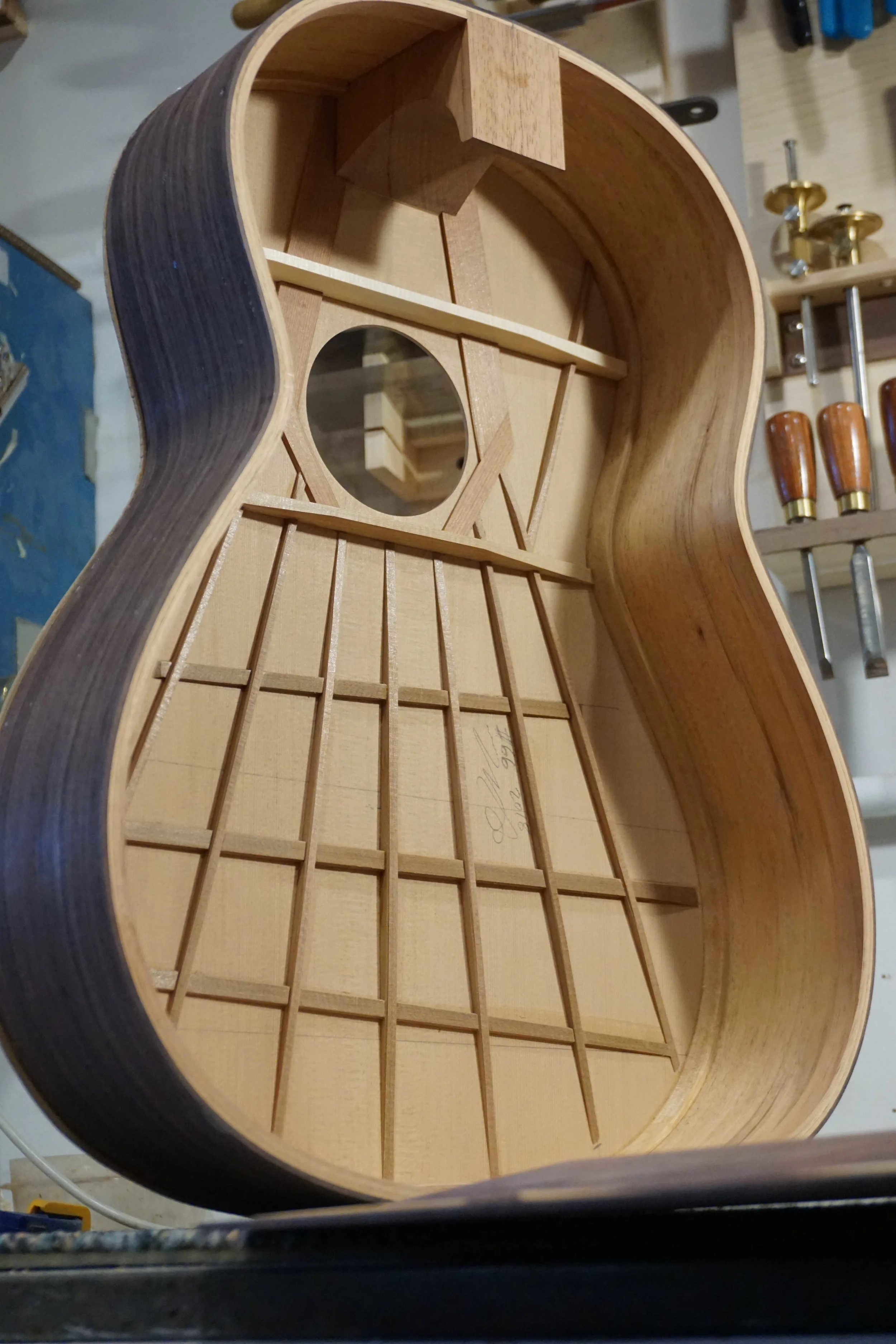 A classical guitar with no back showing the bracing on the top