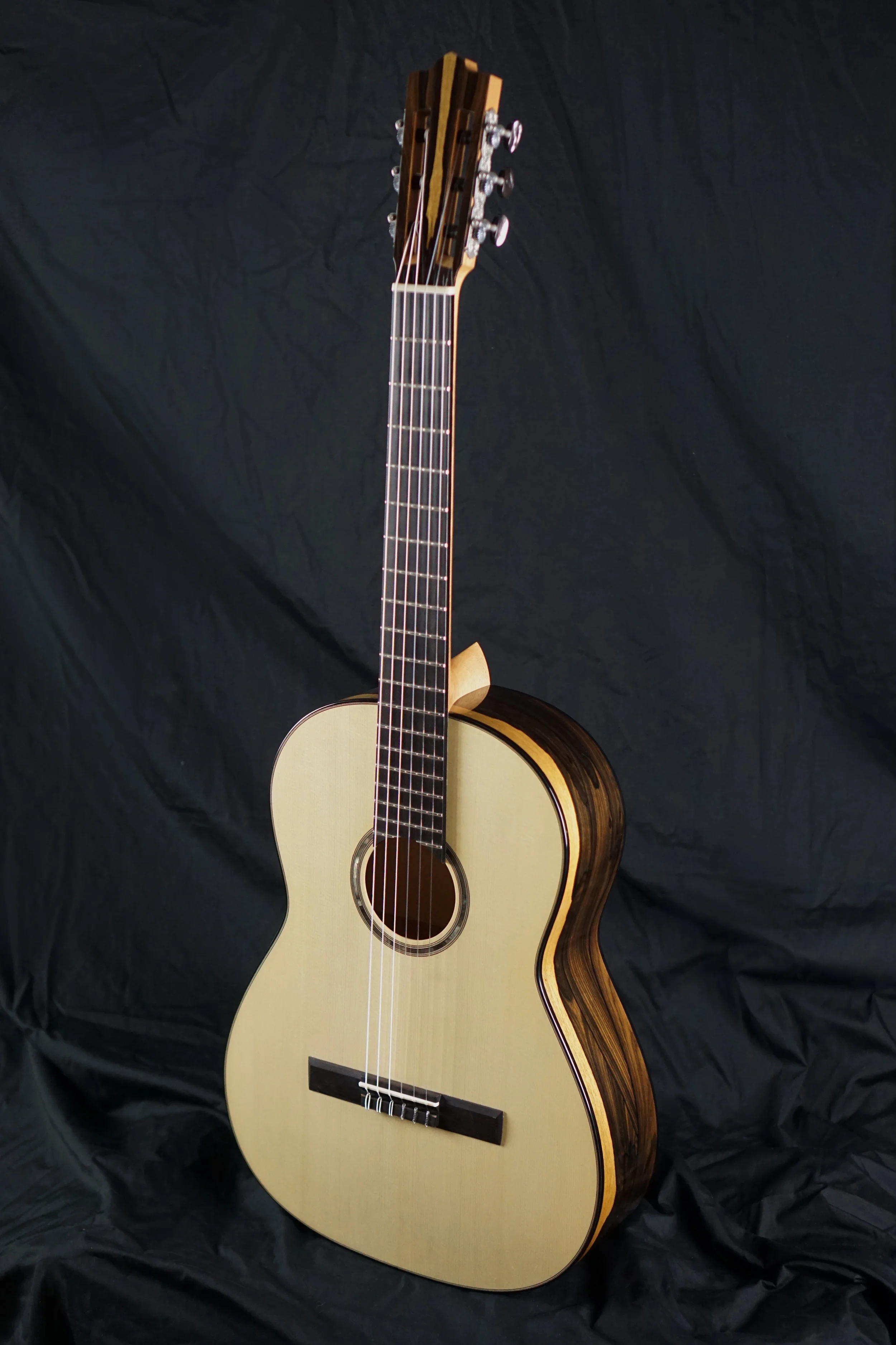 Classical Guitar made with Ziricote Wood photographed from the front on a black background
