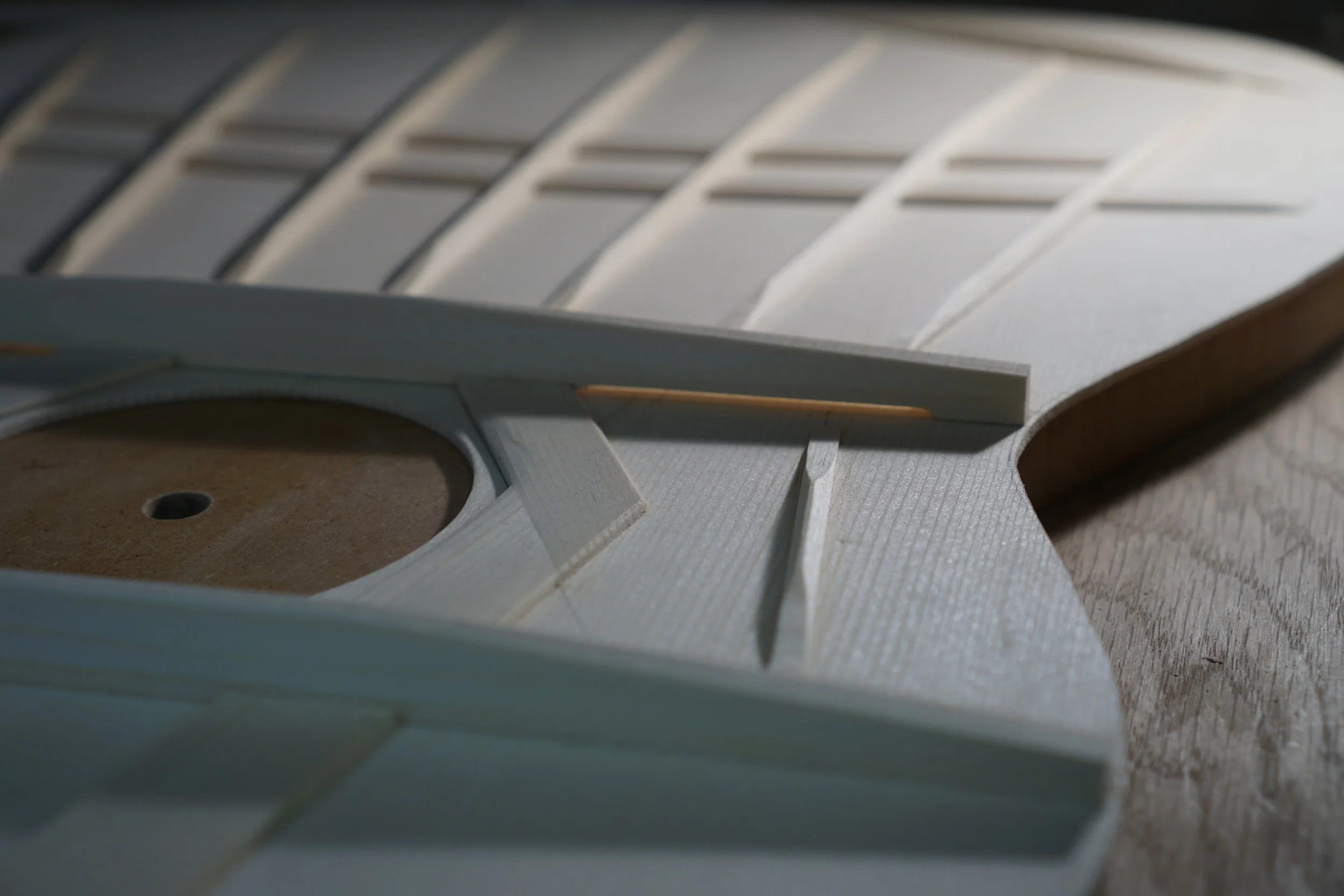 Underside of a classical guitar top during construction showing the bracing and tone bars.