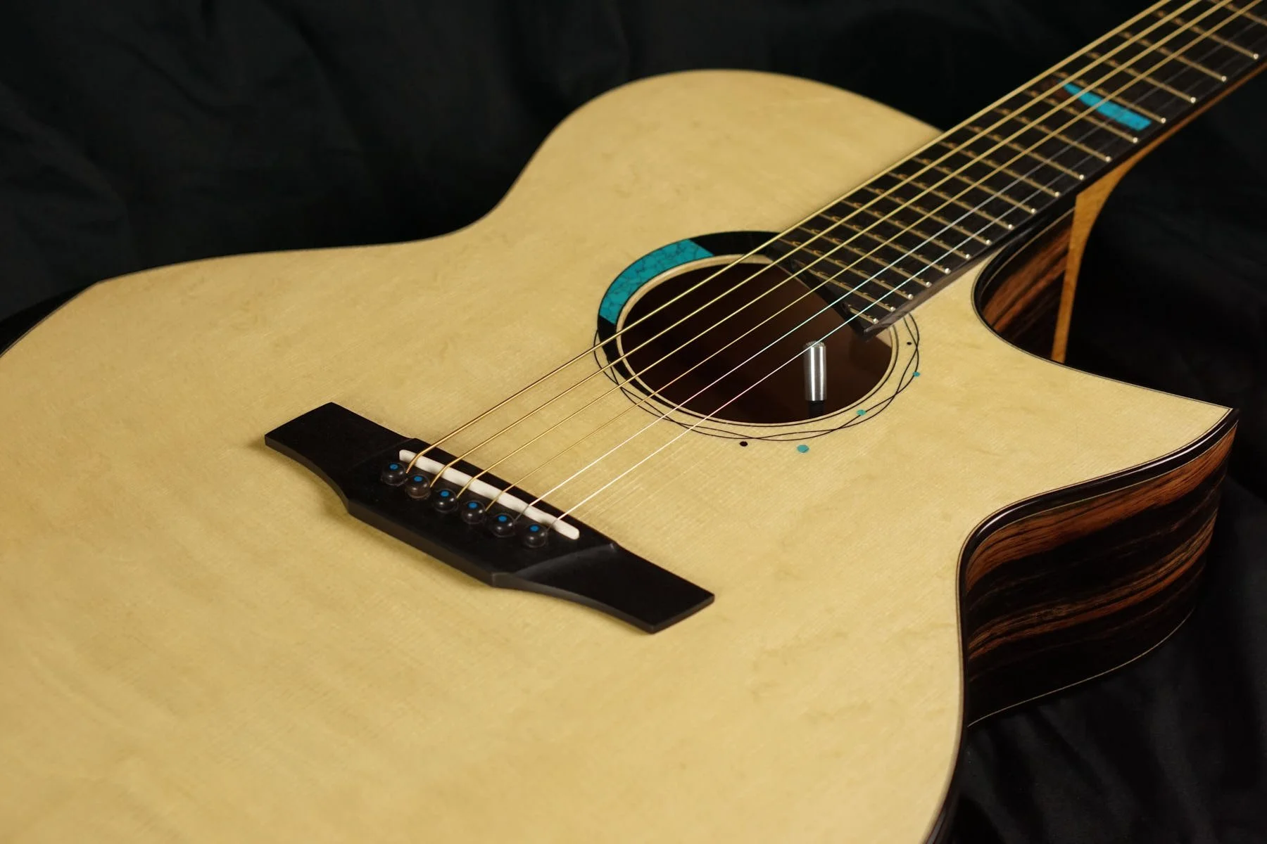Steel string guitar top with a cutaway and custom inlaid rosette.