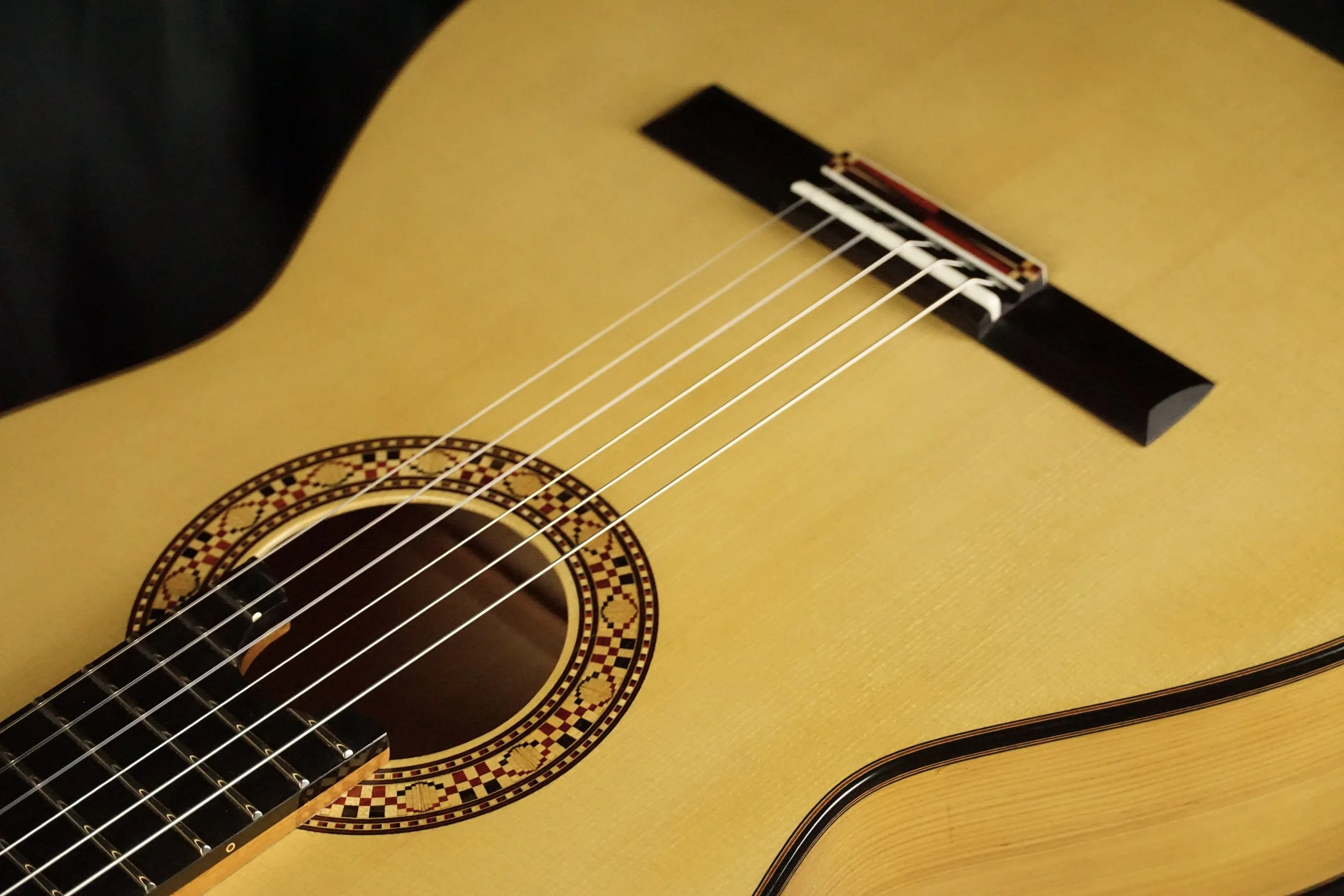 Classical guitar rosette and bridge on a spruce top.
