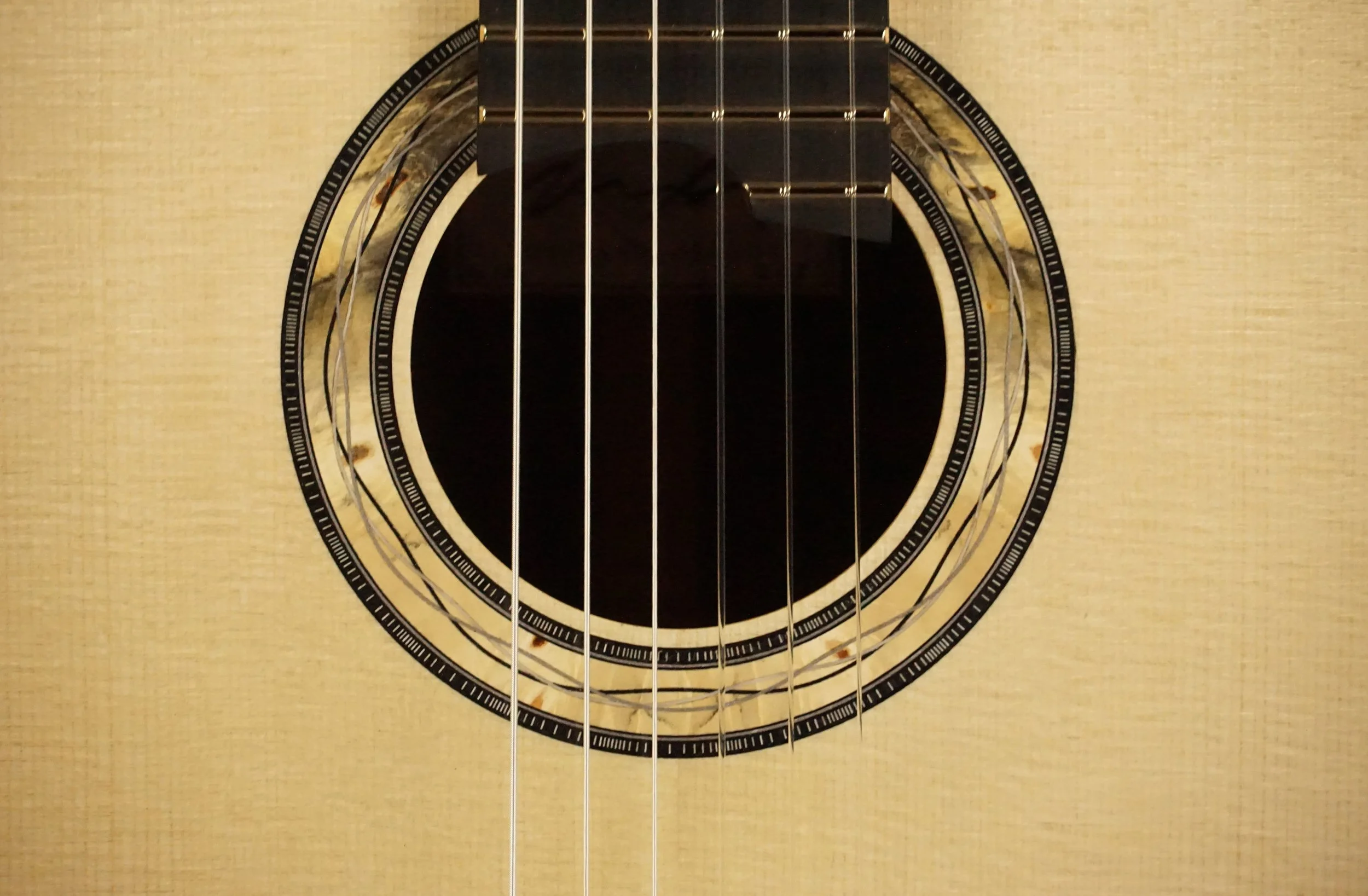 Burl wood rosette on a classical guitar.