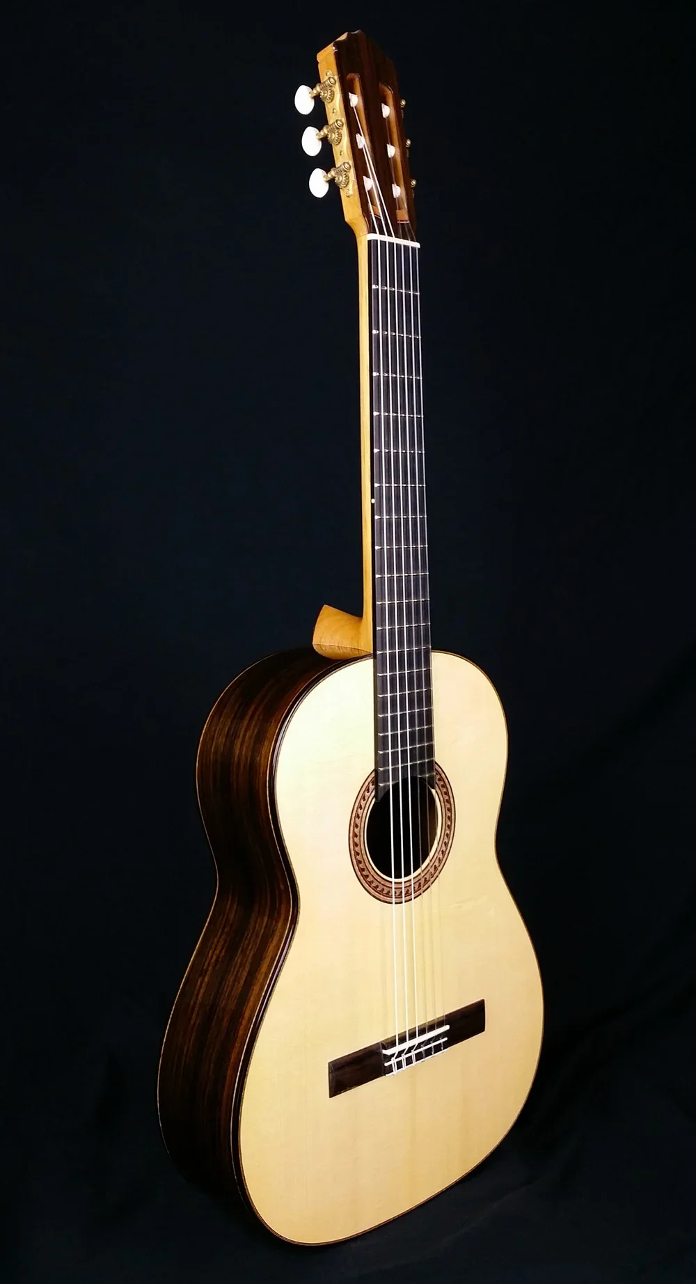 Custom classical guitar on a black background.
