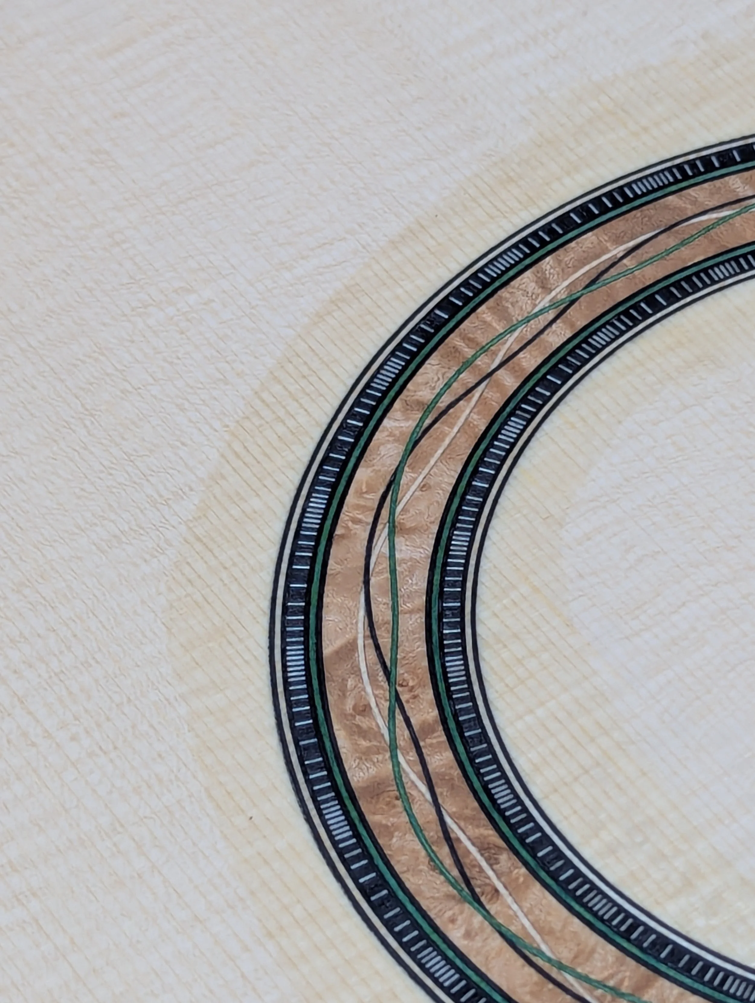 Burl wood rosette finished and waiting for the sound hole to be removed.