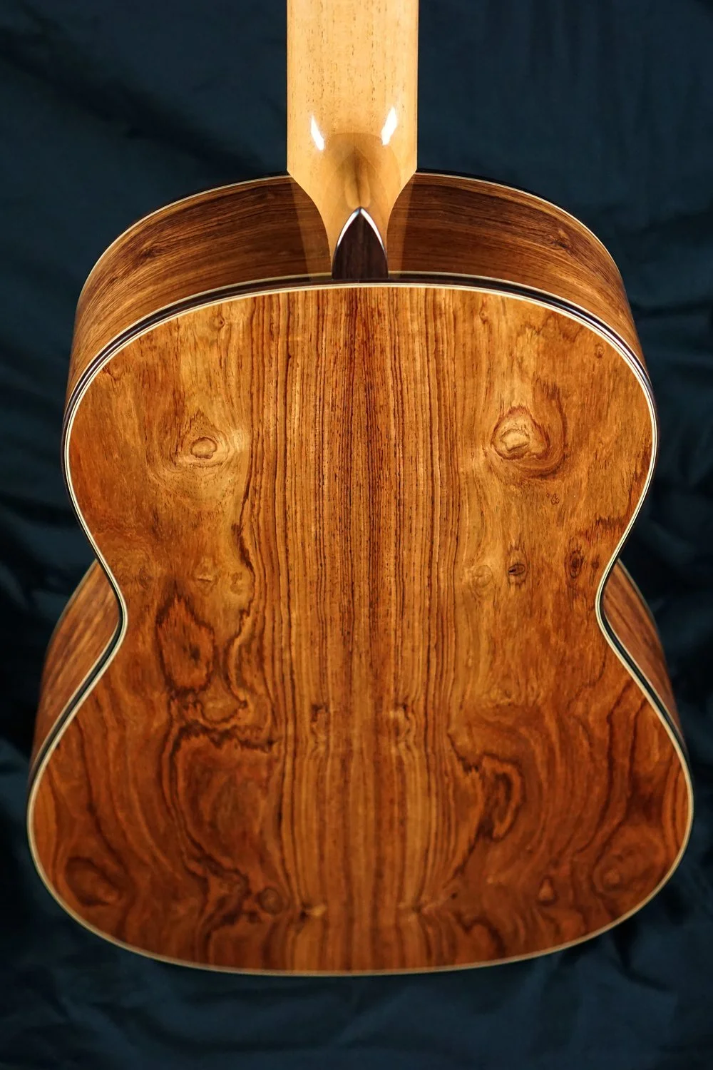Honduran Rosewood Classical guitar back on a black background.