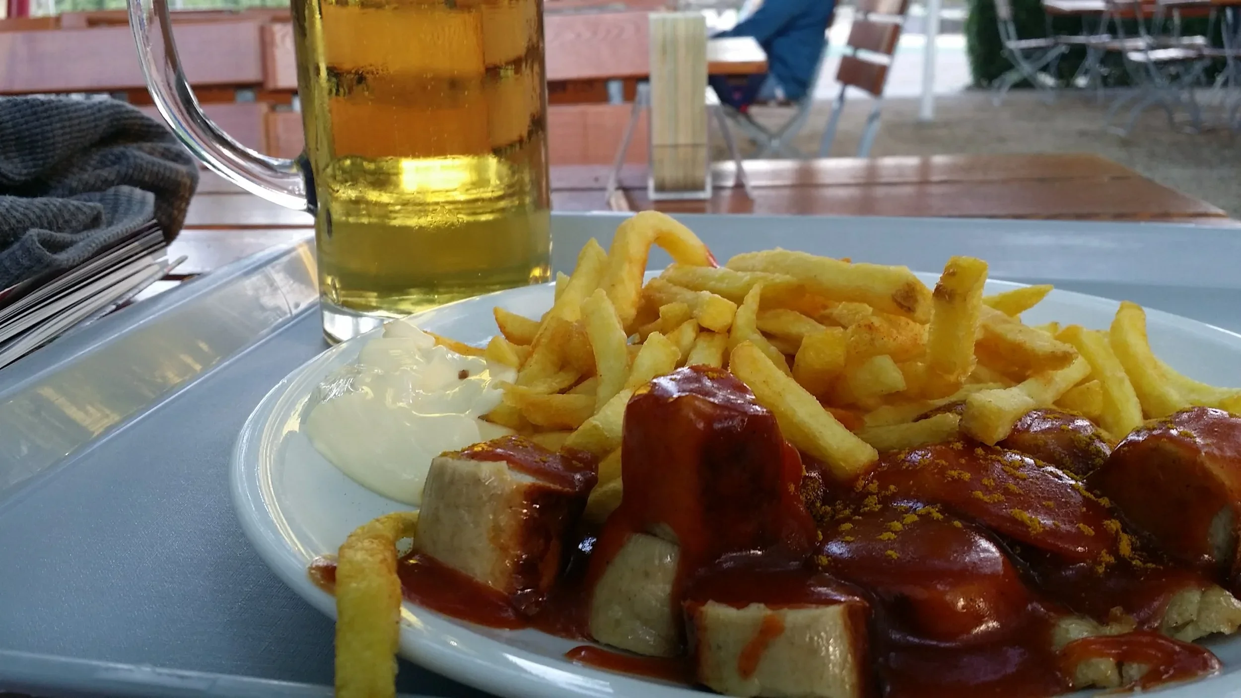 Plate of curry Wurst and fries on an outdoor table