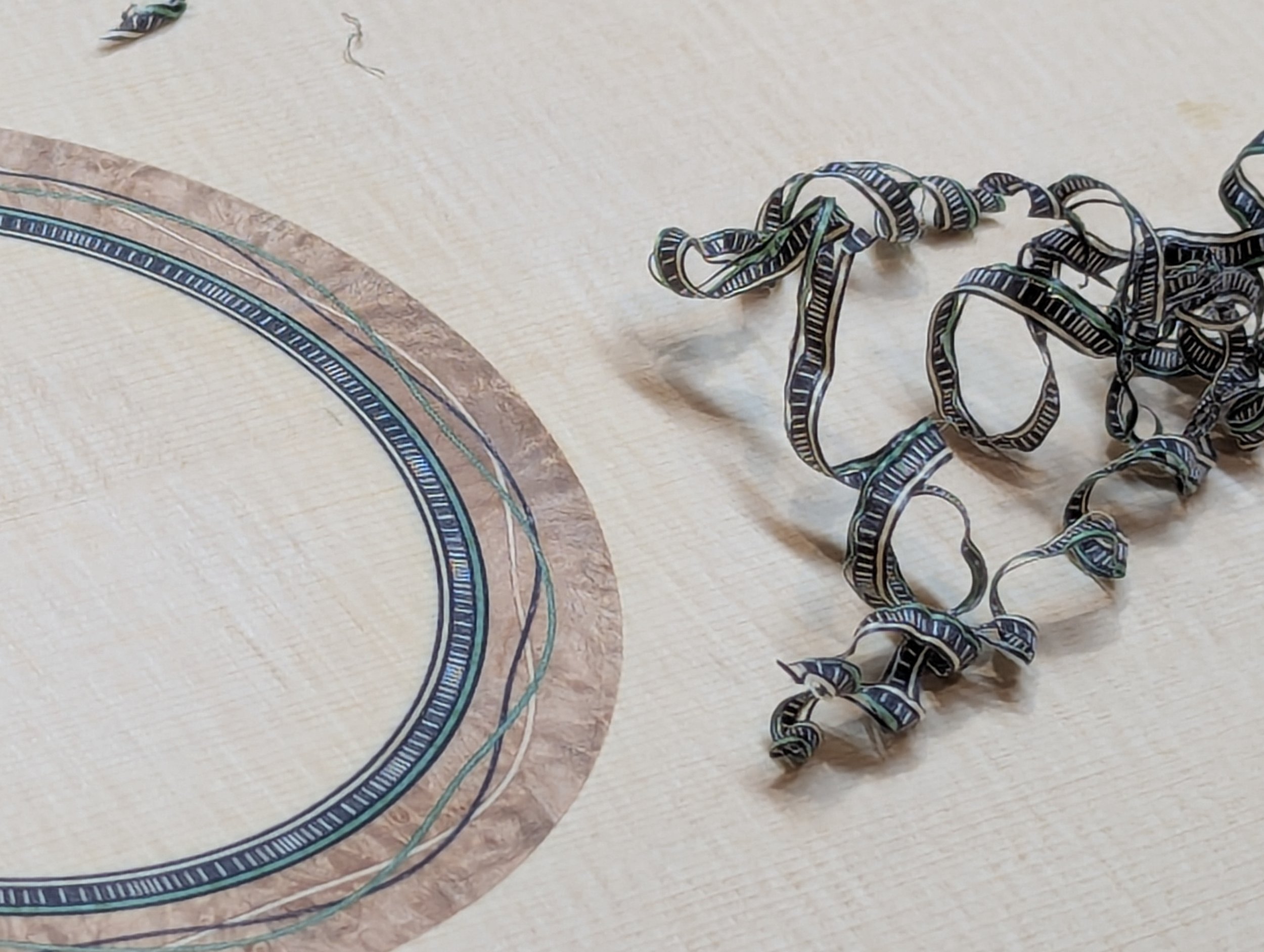 Burl wood rosette complete after being scraped and leveled with shavings.