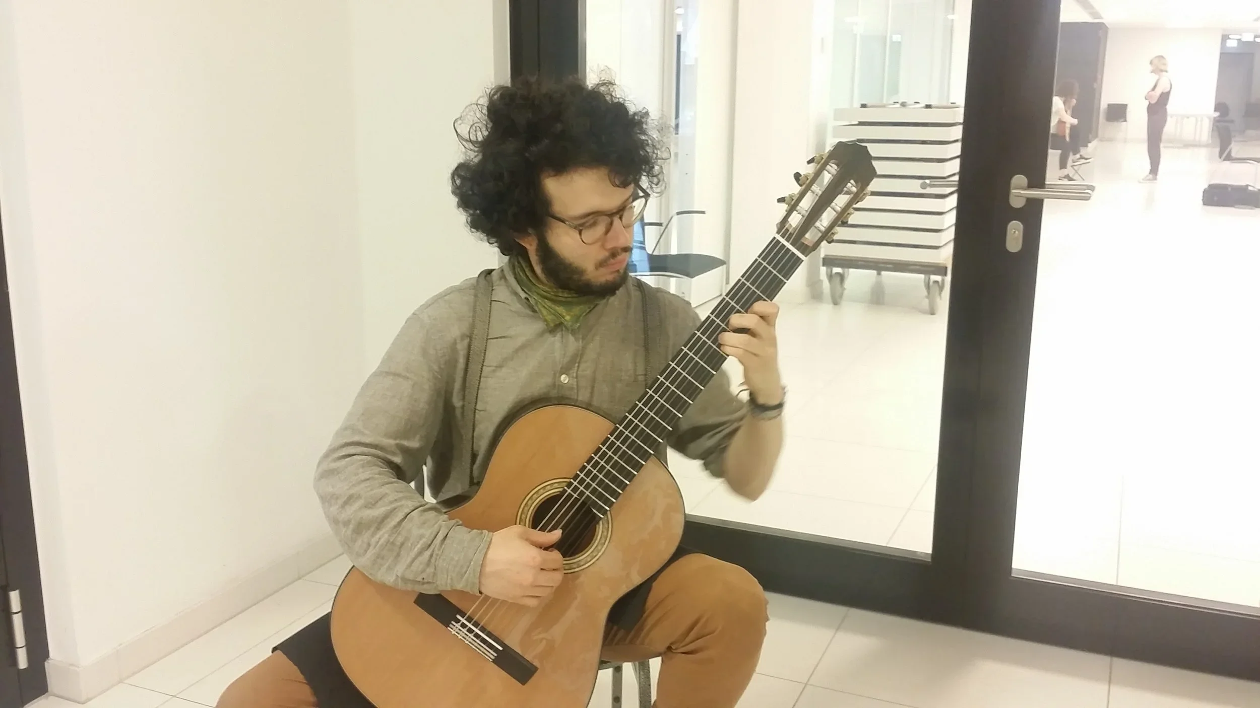 Classical Guitarist seated and playing.