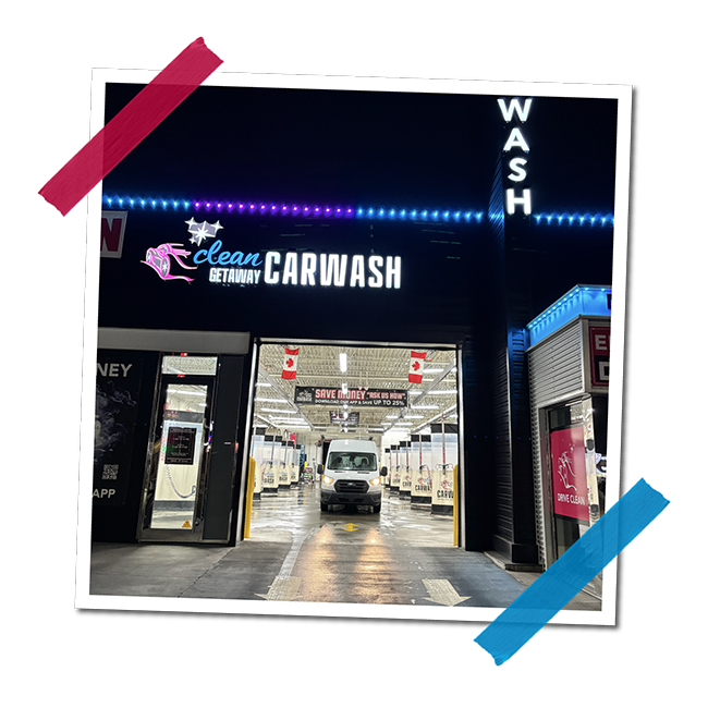 Entrance to a self-service car wash with bright neon signs and a white van inside the washing bay.