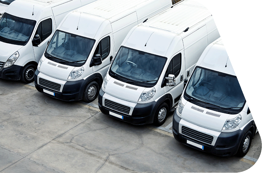 A row of white delivery vans parked in a lot, viewed from above.