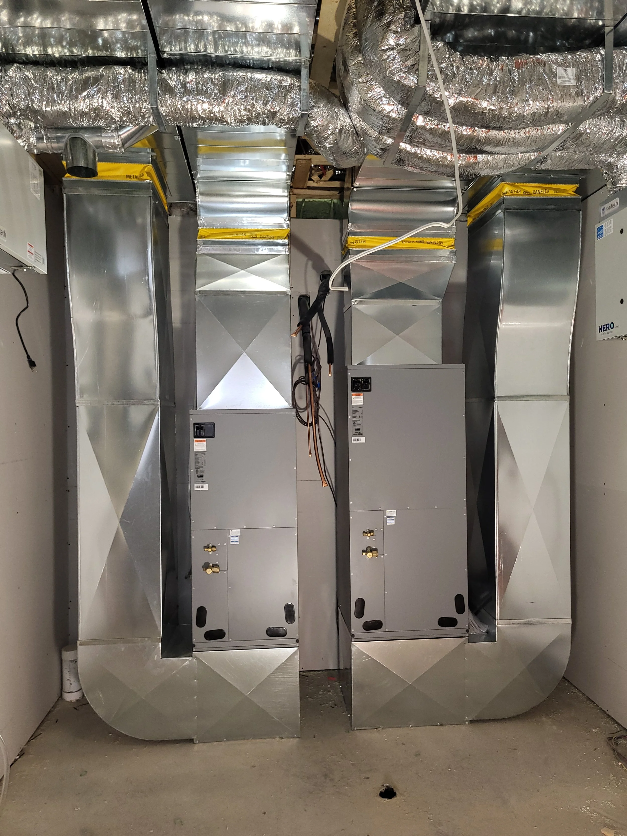 HVAC ductwork and metal electrical boxes in a utility room. Ventilation and sheet metal, ducted heat pumps