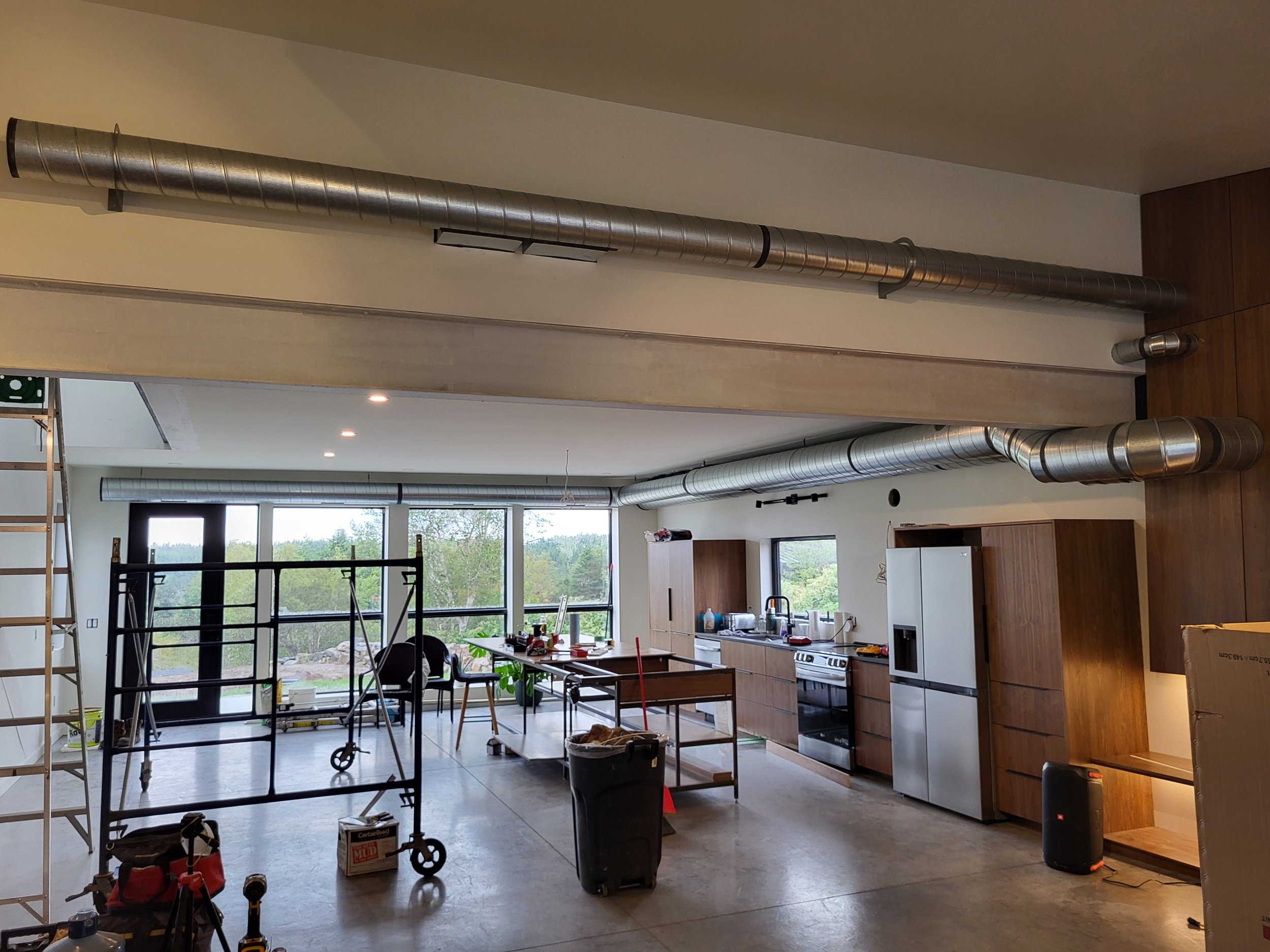 Modern kitchen under renovation with exposed industrial ductwork running along the ceiling. air flow