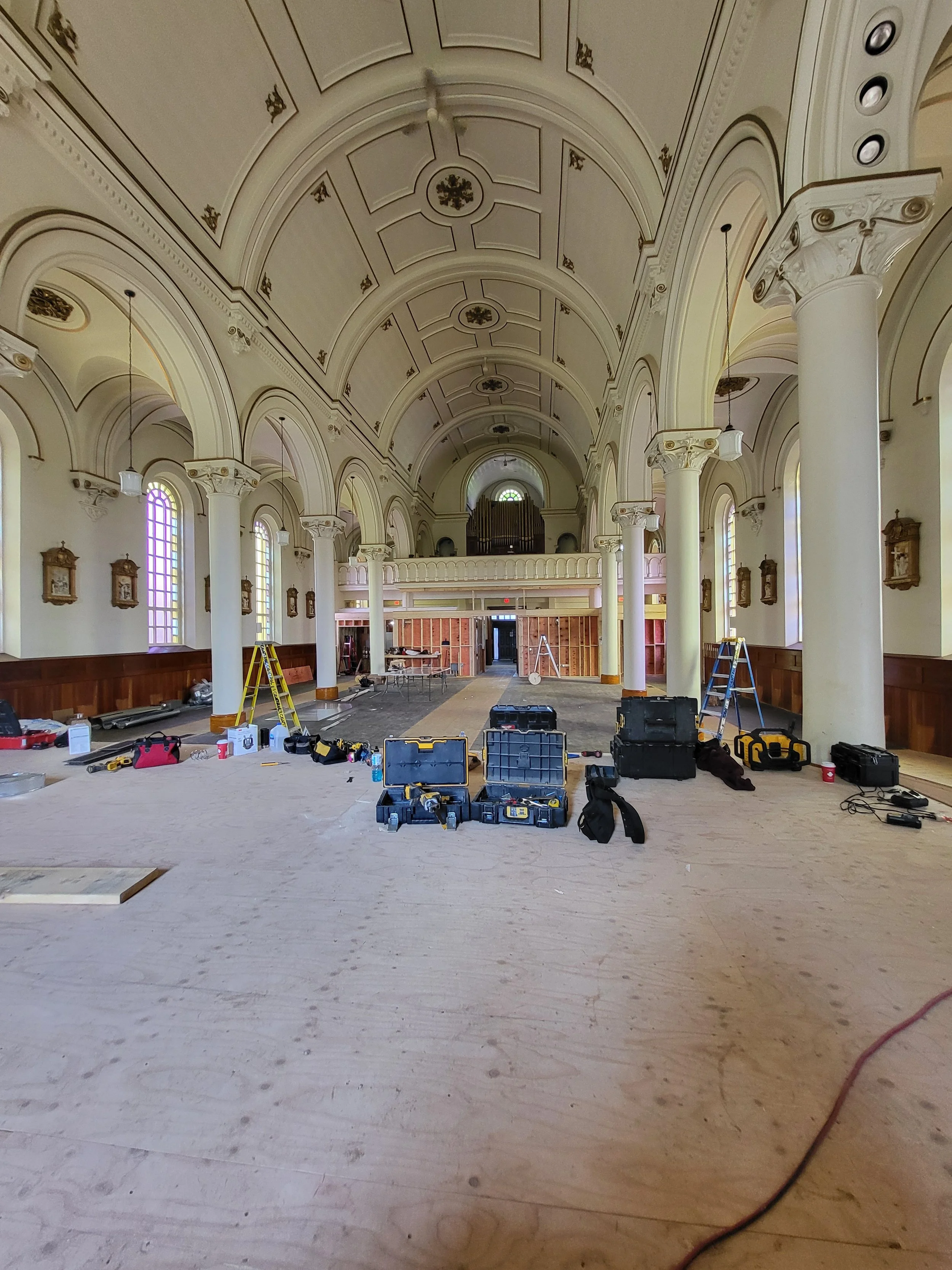 Interior of a church undergoing renovation, with construction tools, commercial HVAC and ventilation