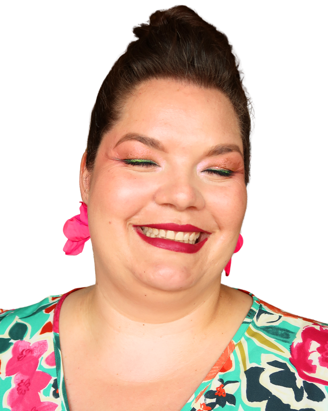 Portrait d'une femme souriante avec maquillage coloré et vêtements aux motifs floraux.