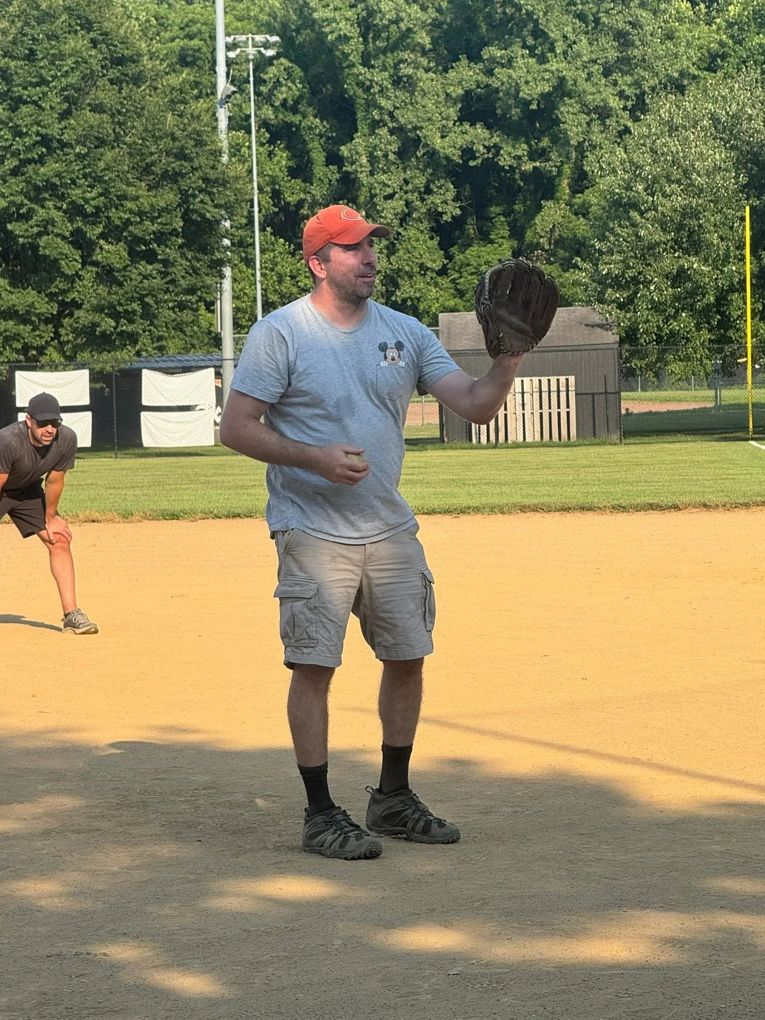 Dan acting as a coach by pitching softball to his son's team