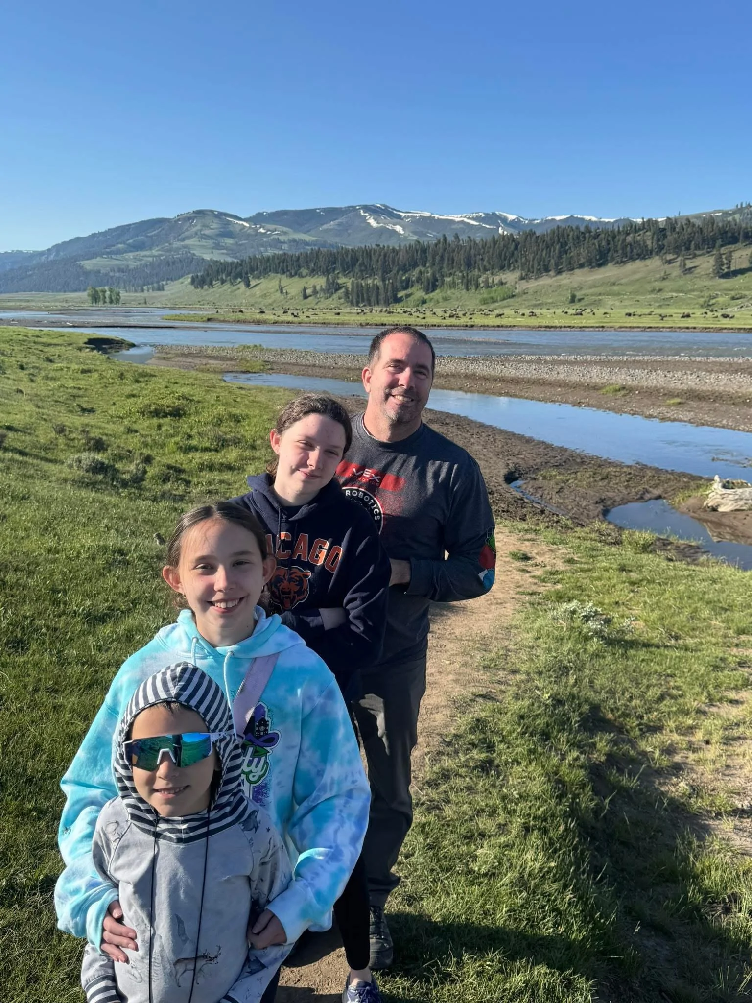 Our family at Yellowstone National Park. The dots in the distance beyond the river is a herd of Buffalo