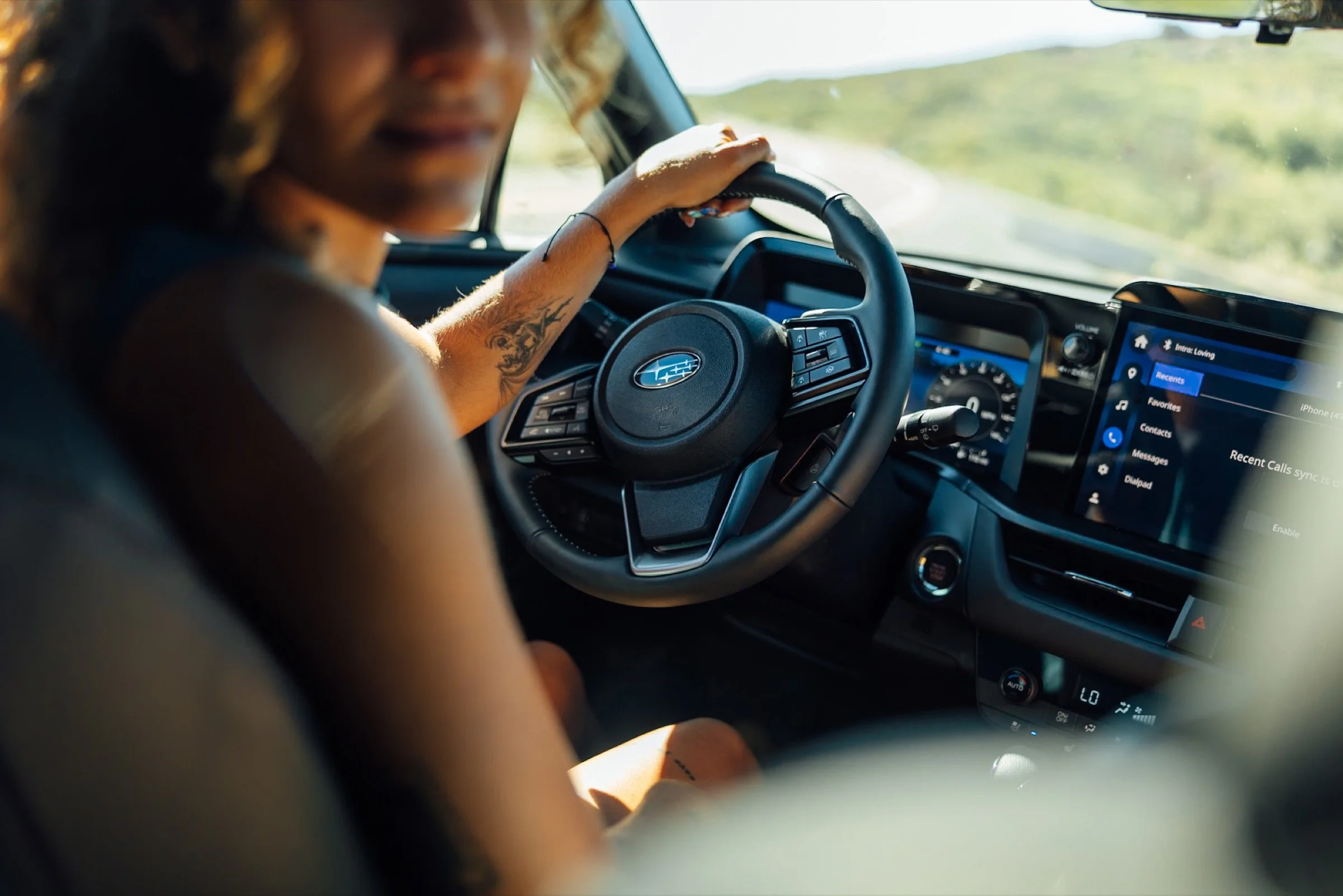 Driver's hand on the wheel inside the Subaru Outback