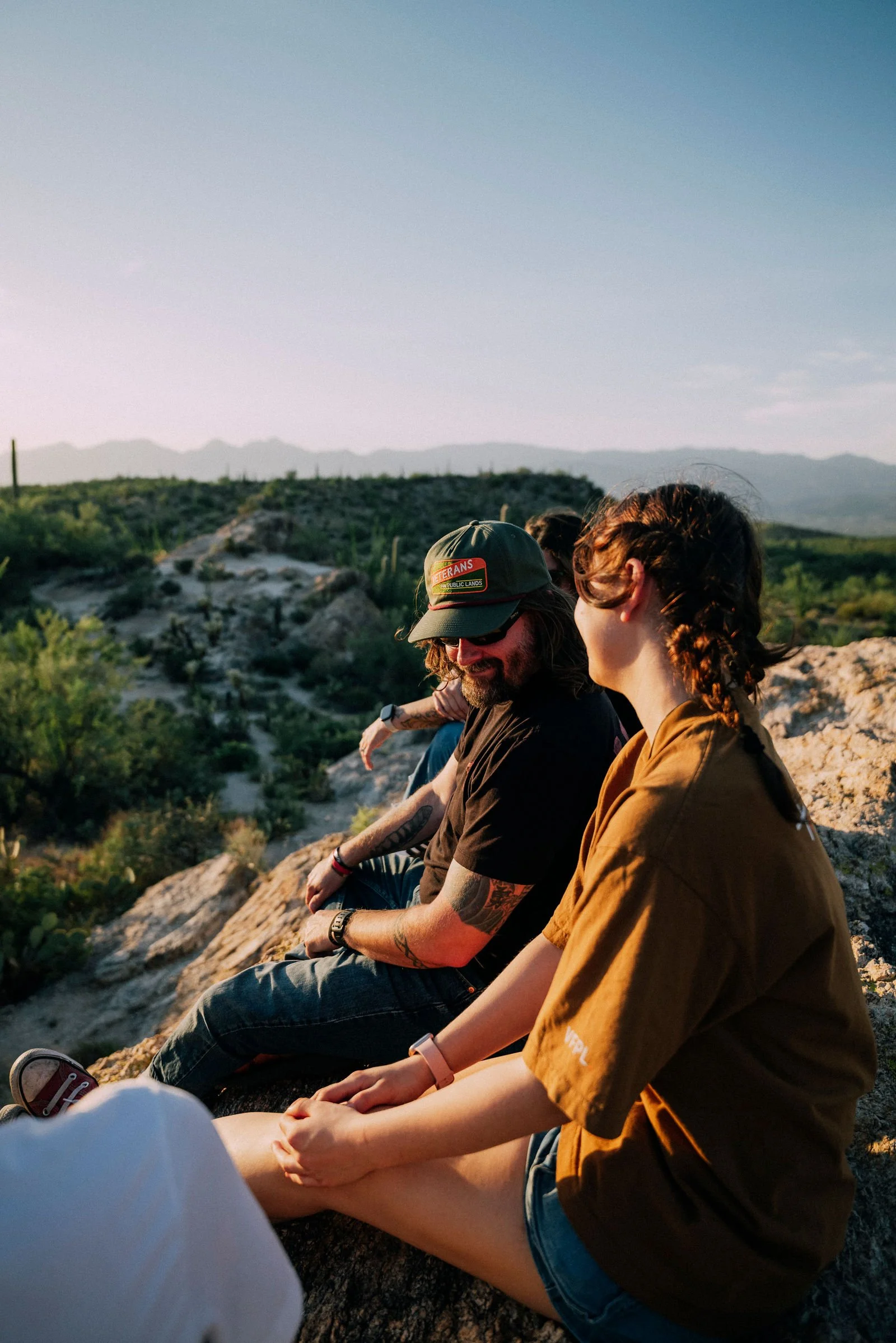 Chappy sitting on a rock beside a woman, overlooking the desert
