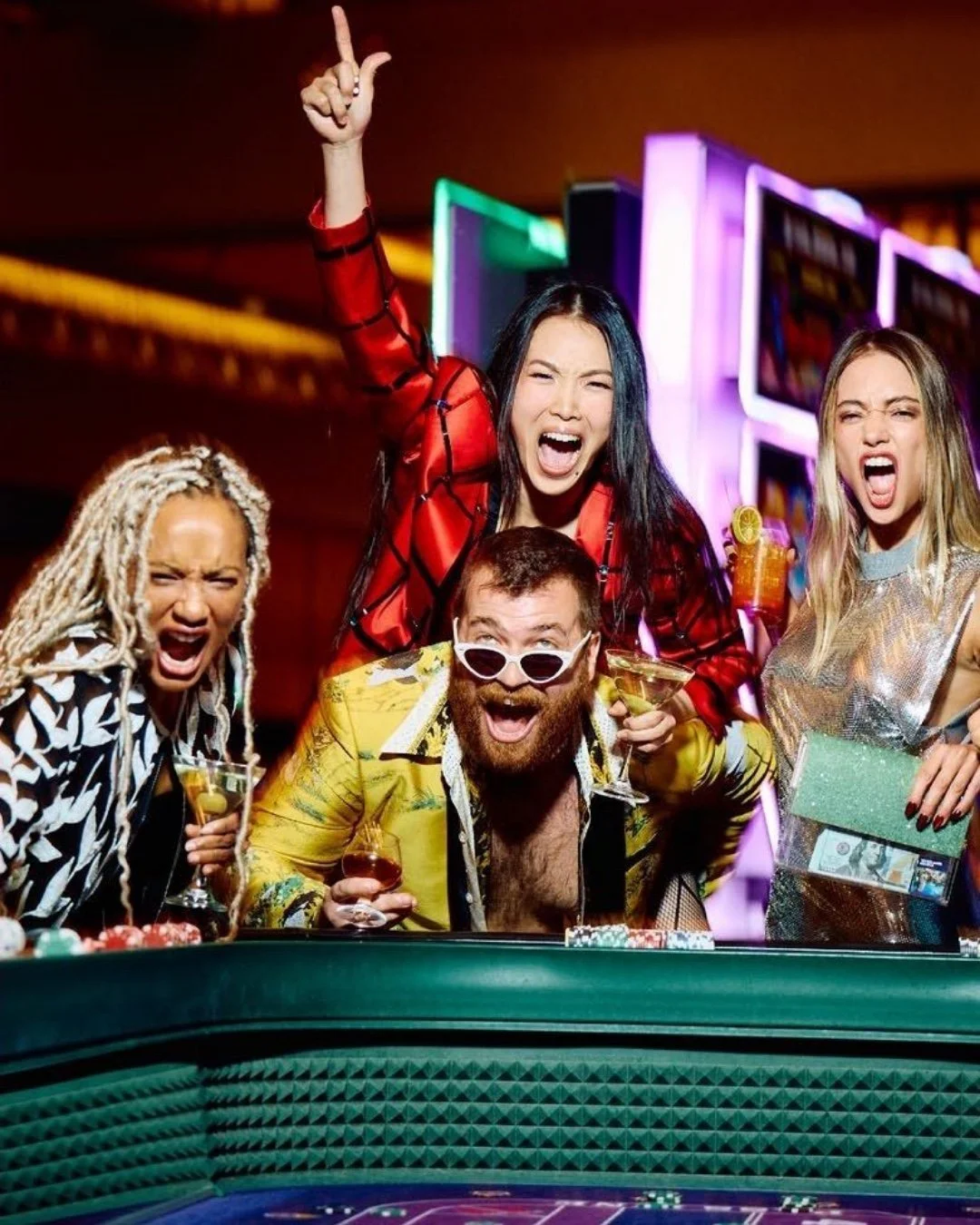 Group of friends cheering at a casino table under neon lights