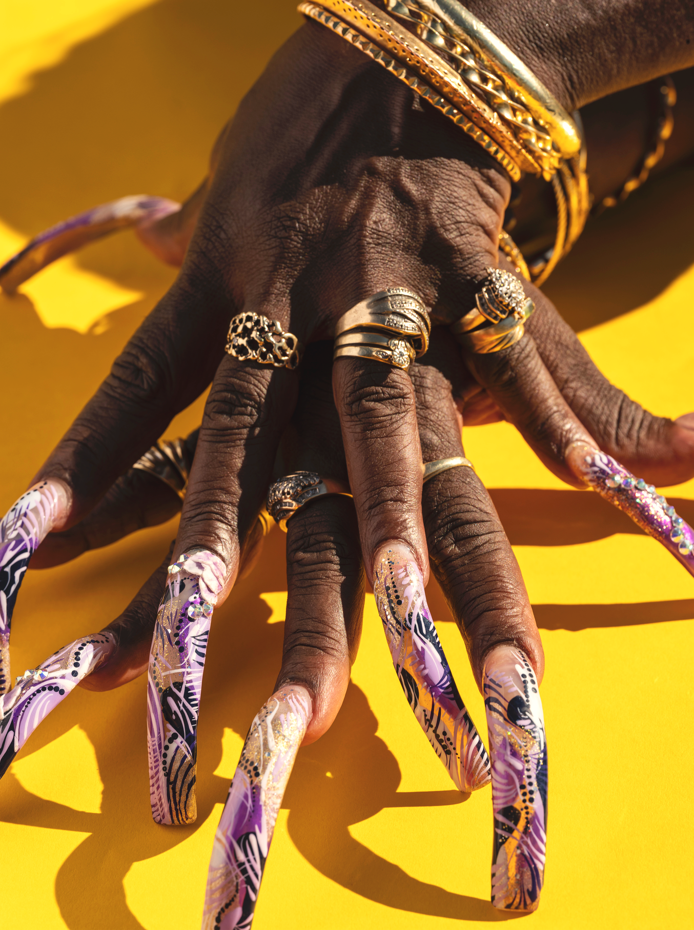 Fancy nails on bright yellow backdrop photographed by lifestyle and western photographer Gabriela Hasbun.