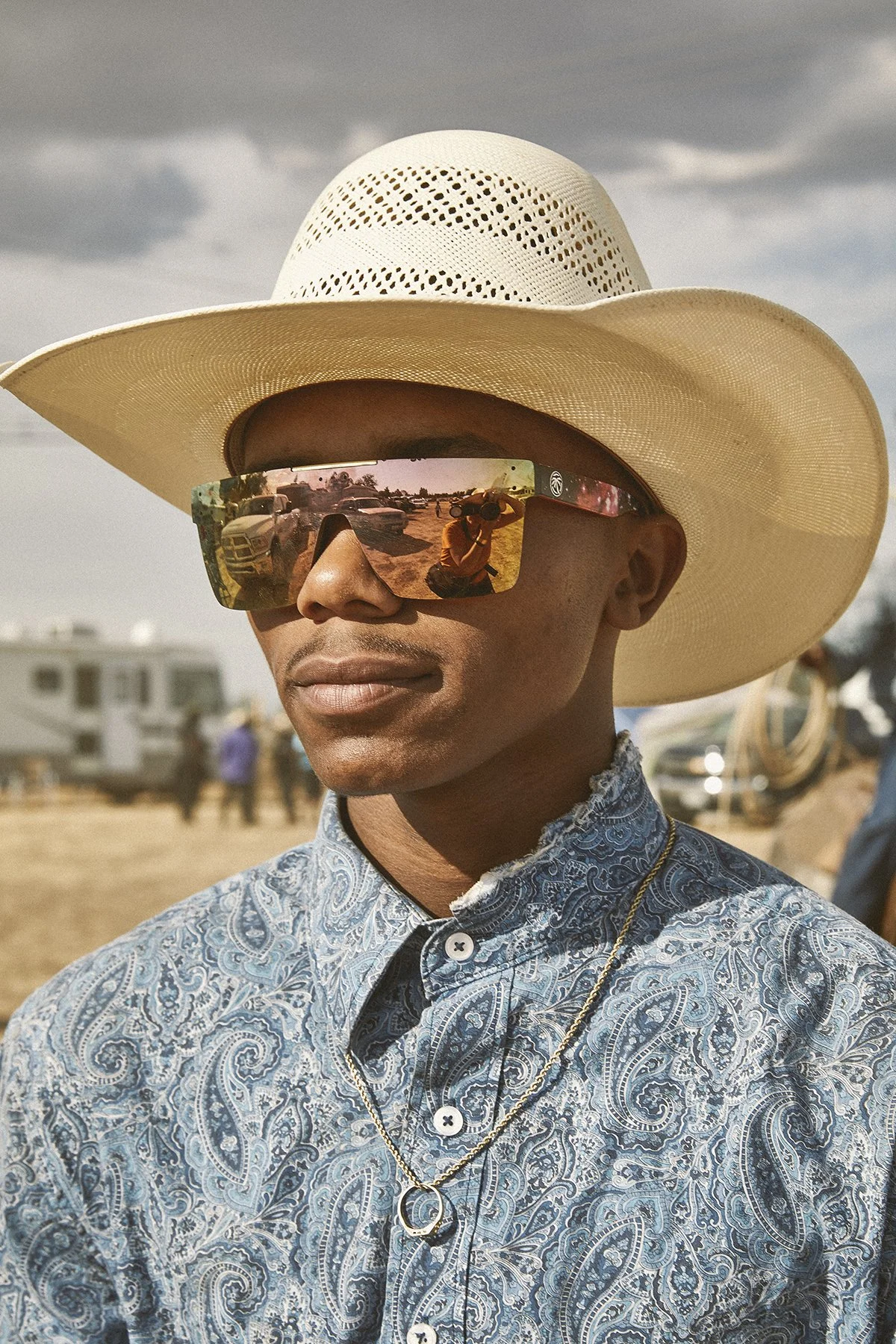 Black cowboy, Jordan Miller, wears sunglasses at rideout.