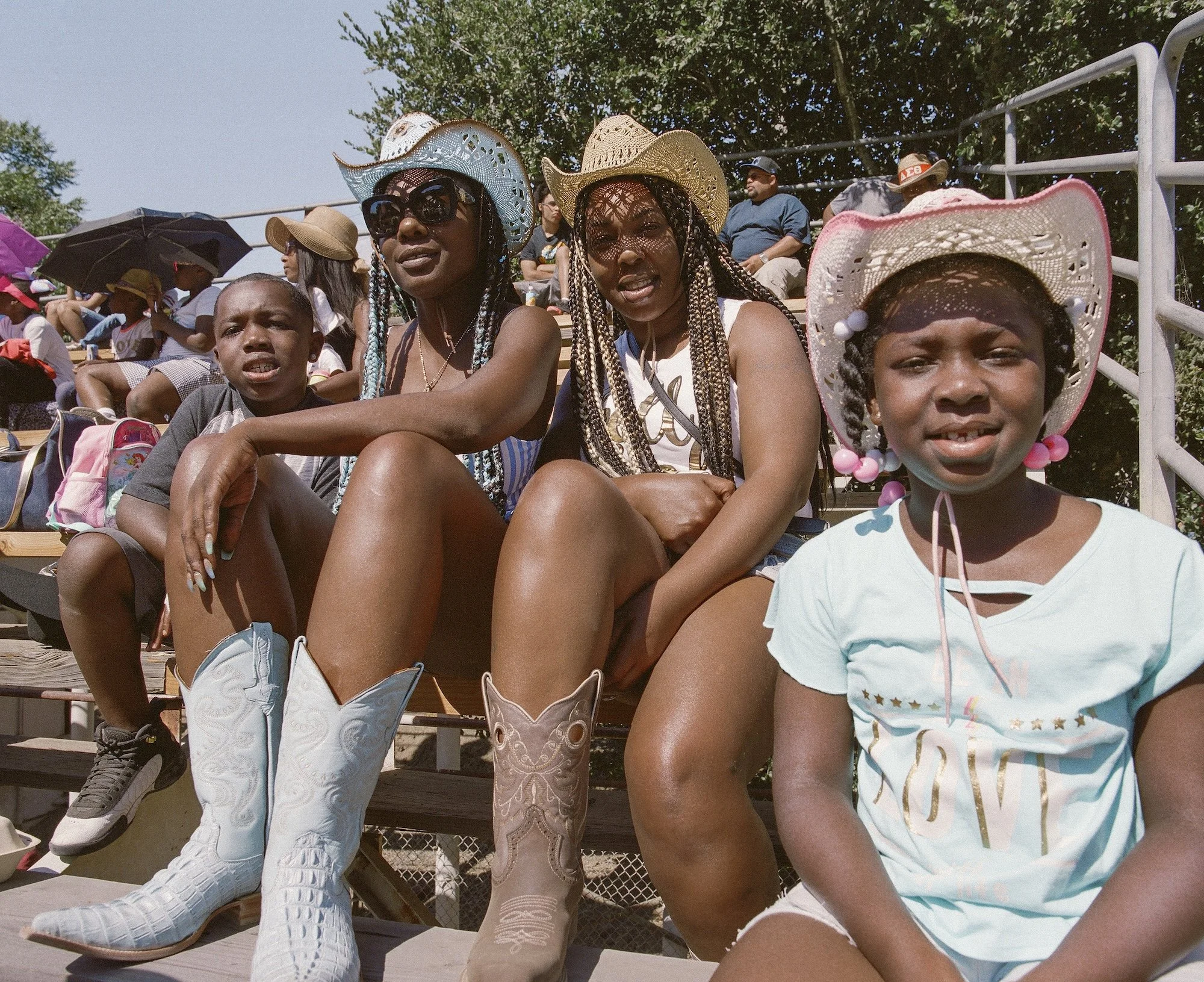 A family of cowboys and cowgirls attend the Bill Pickett Invitational Rodeo in Oakland, photographed by Gabriela Hasbun.