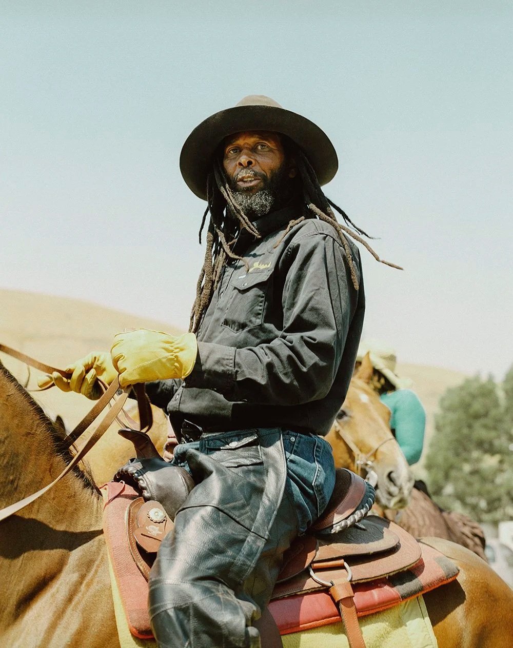 Black cowboy riding his horse in Oakland, photographed by San Francisco–based photographer Gabriela Hasbun.