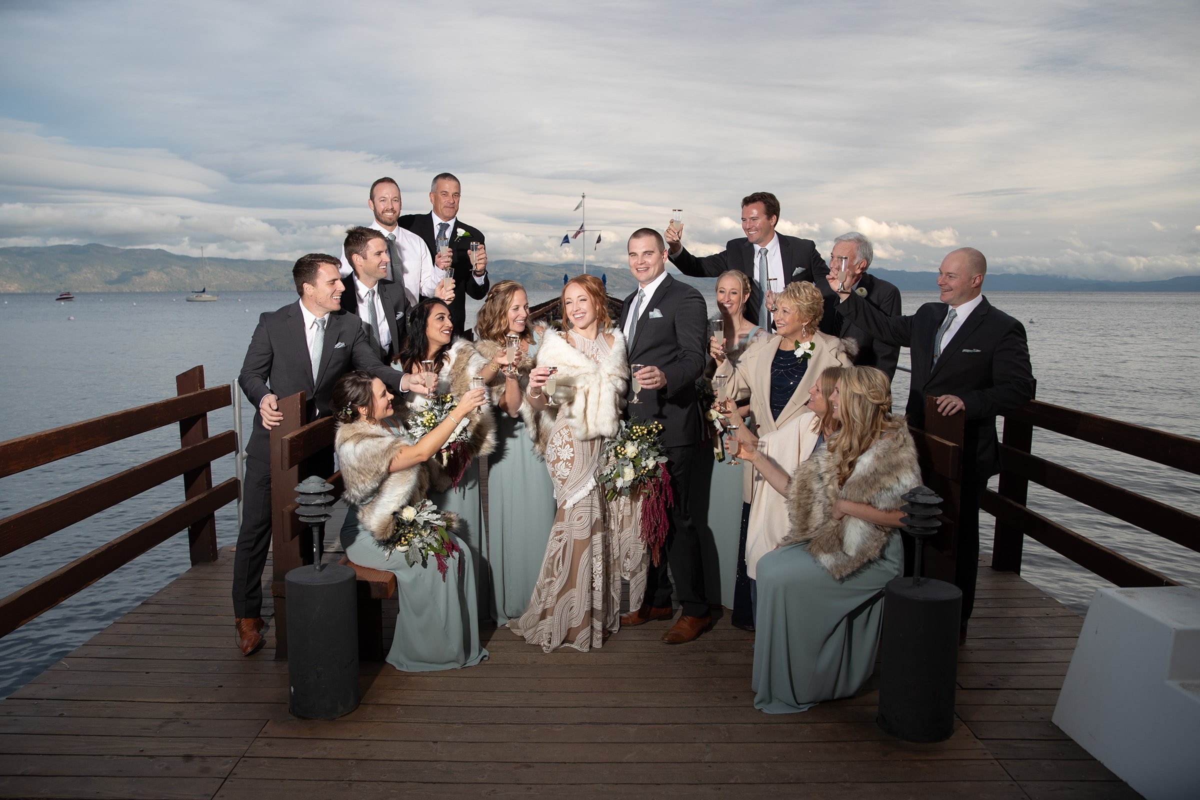 Couple and family laughing together by the iconic Gar Woods sign with the lake in full view behind them..jpg