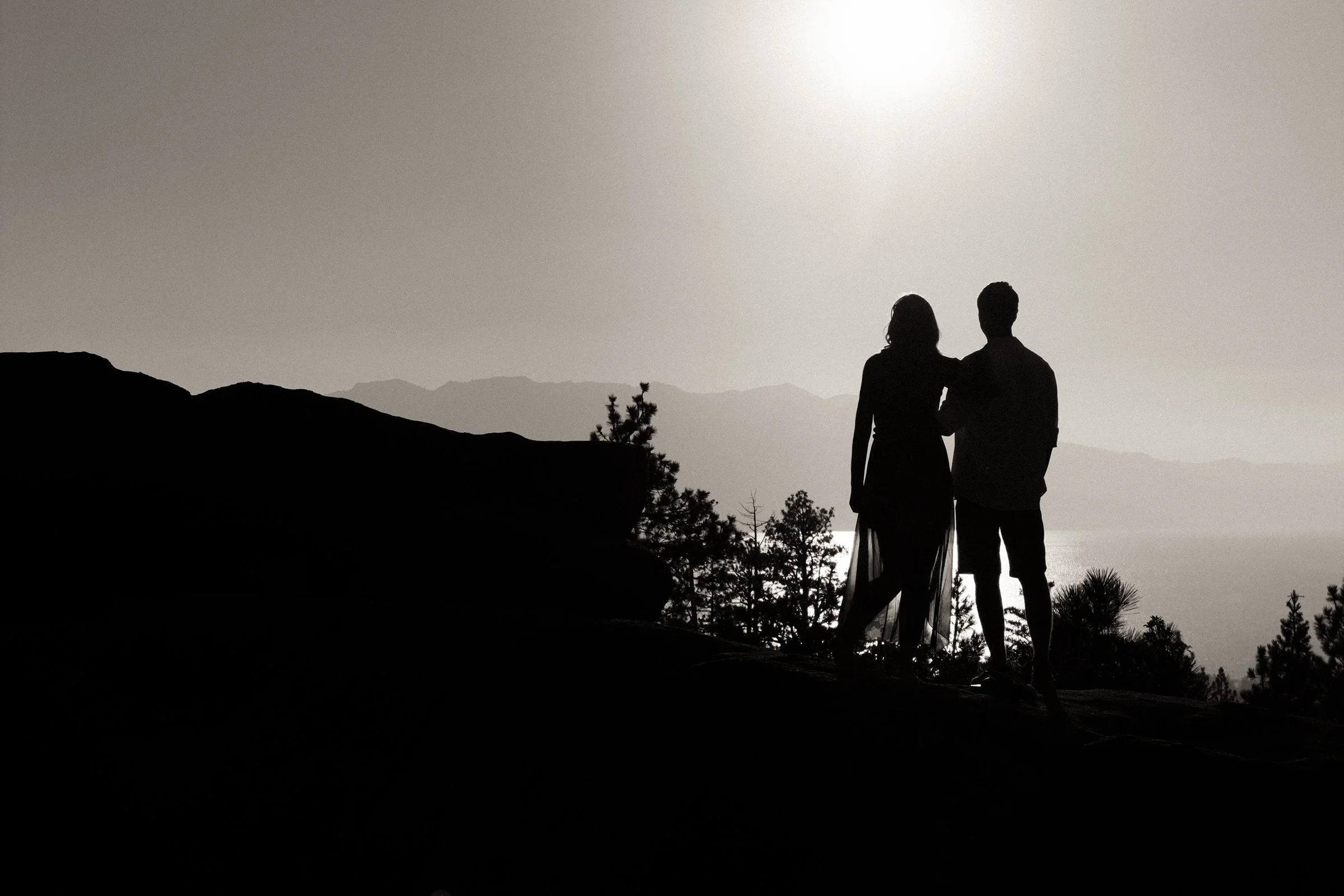 couple on boulder overlooking Lake Tahoe
