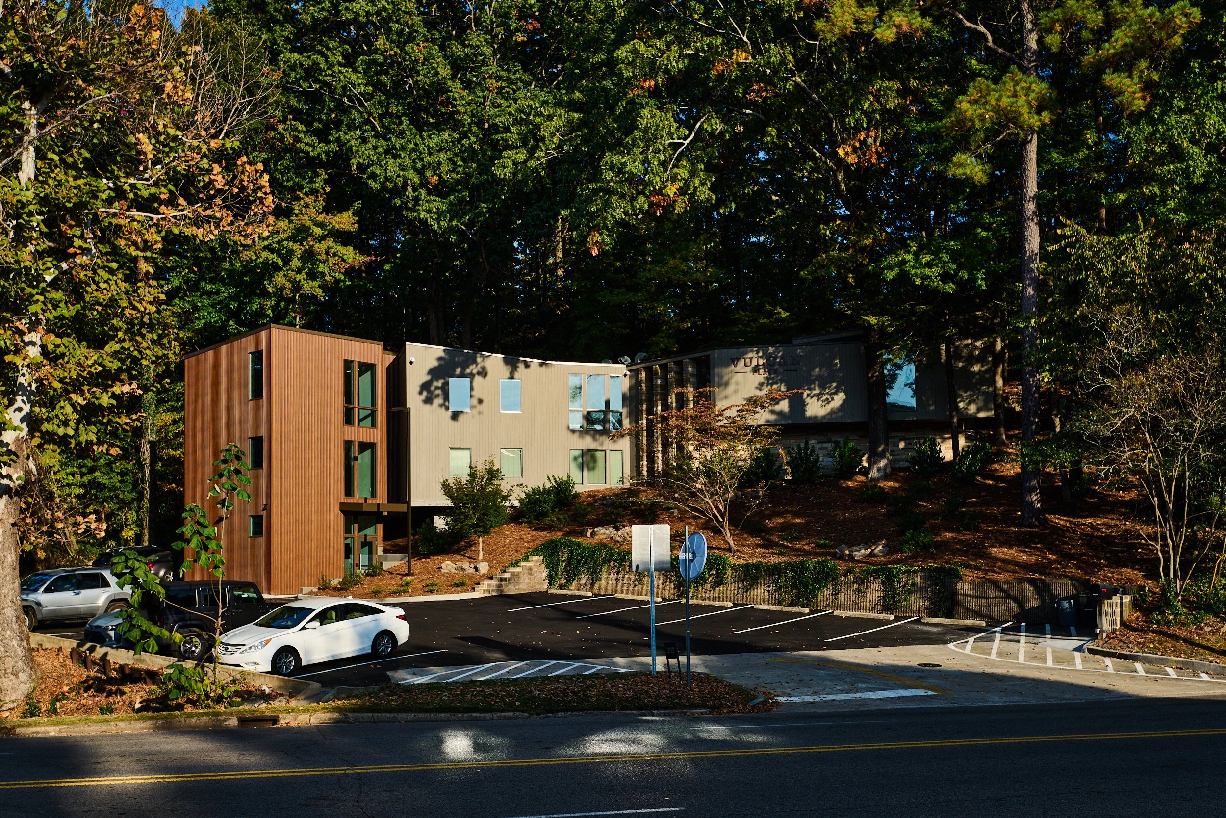 A modern, multi-story building at Vulcan Place in Birmingham, AL nestled in the woods. project by B Group Architecture, Inc.