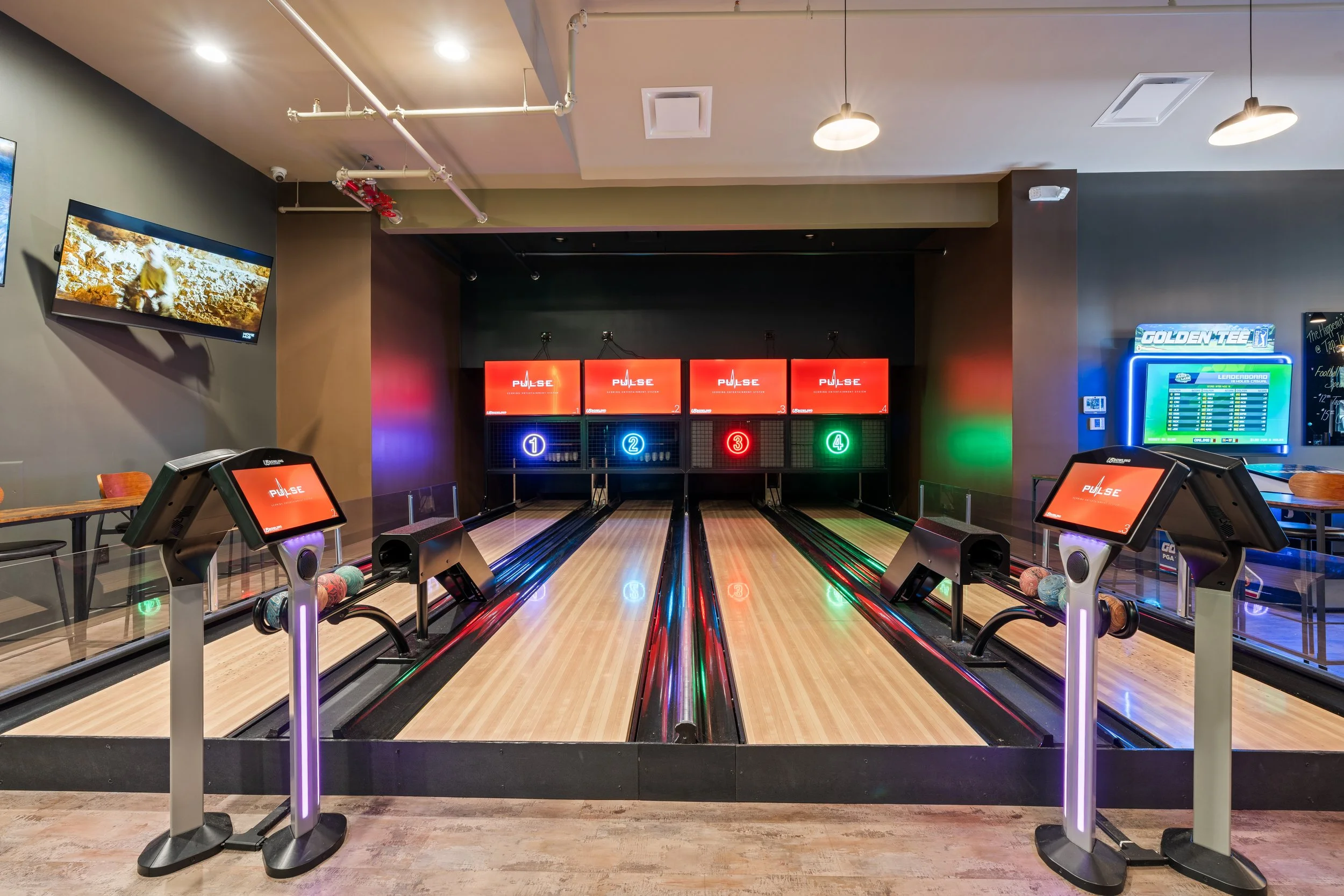 Indoor duck pin bowling alley with four lanes and electronic score screens. project by B Group Architecture, Inc