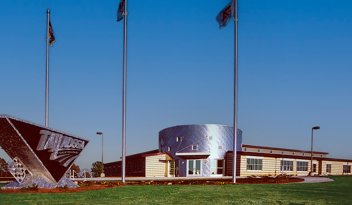 Exterior view of Talledega Super Speedway showcasing a round metal siding entrance. project  by B Group Architecture, Inc.  